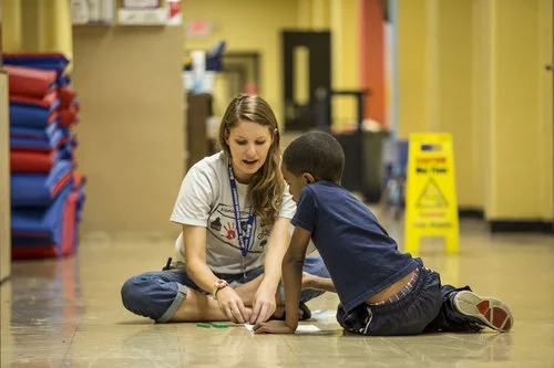 An MTR Camp instructor develops literacy skills with a young student (above).