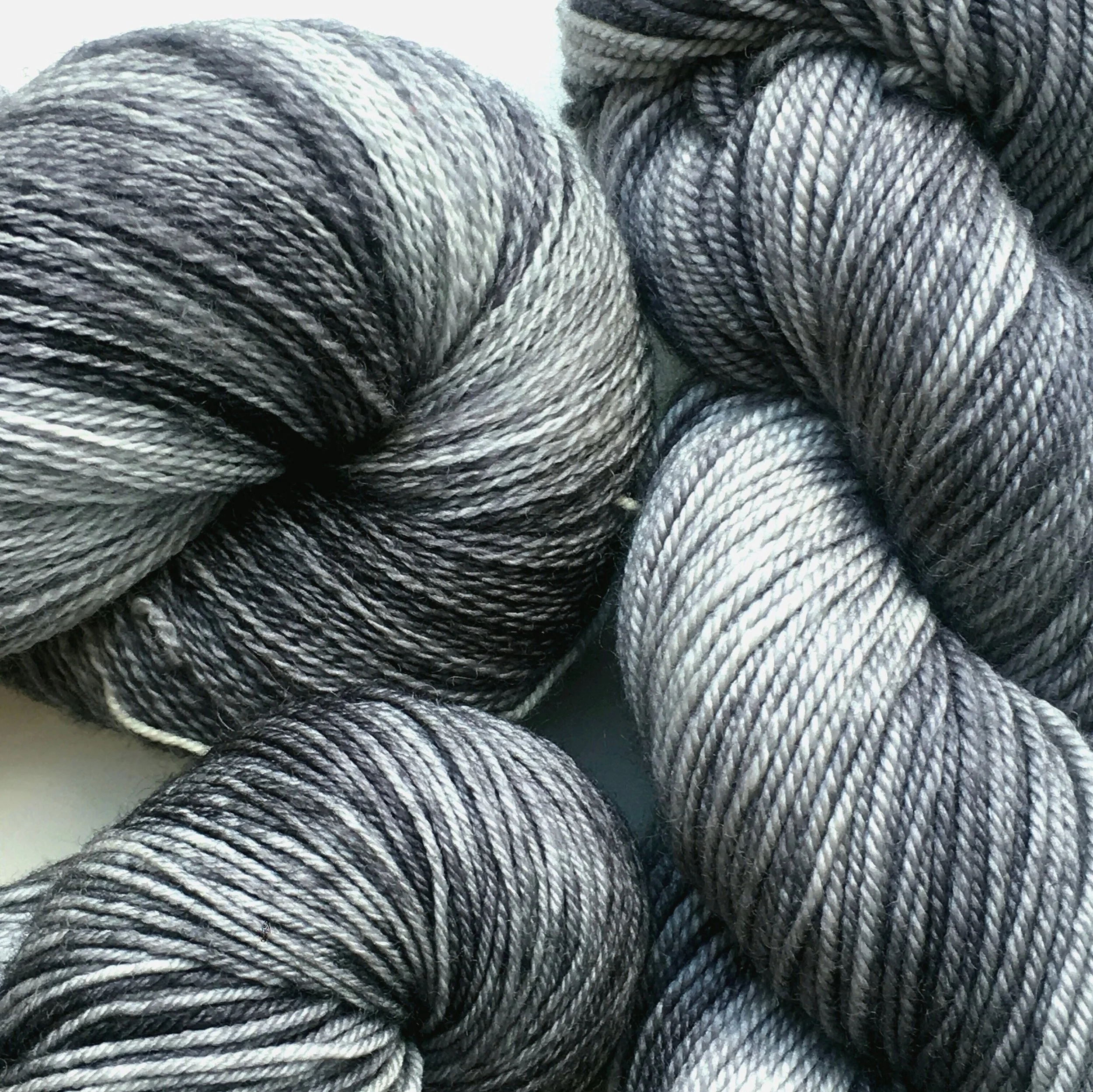 Graphite Neutral, tonal grey. Shown on All Your Base, Sheepy Feet, and Silky Merino Sport.