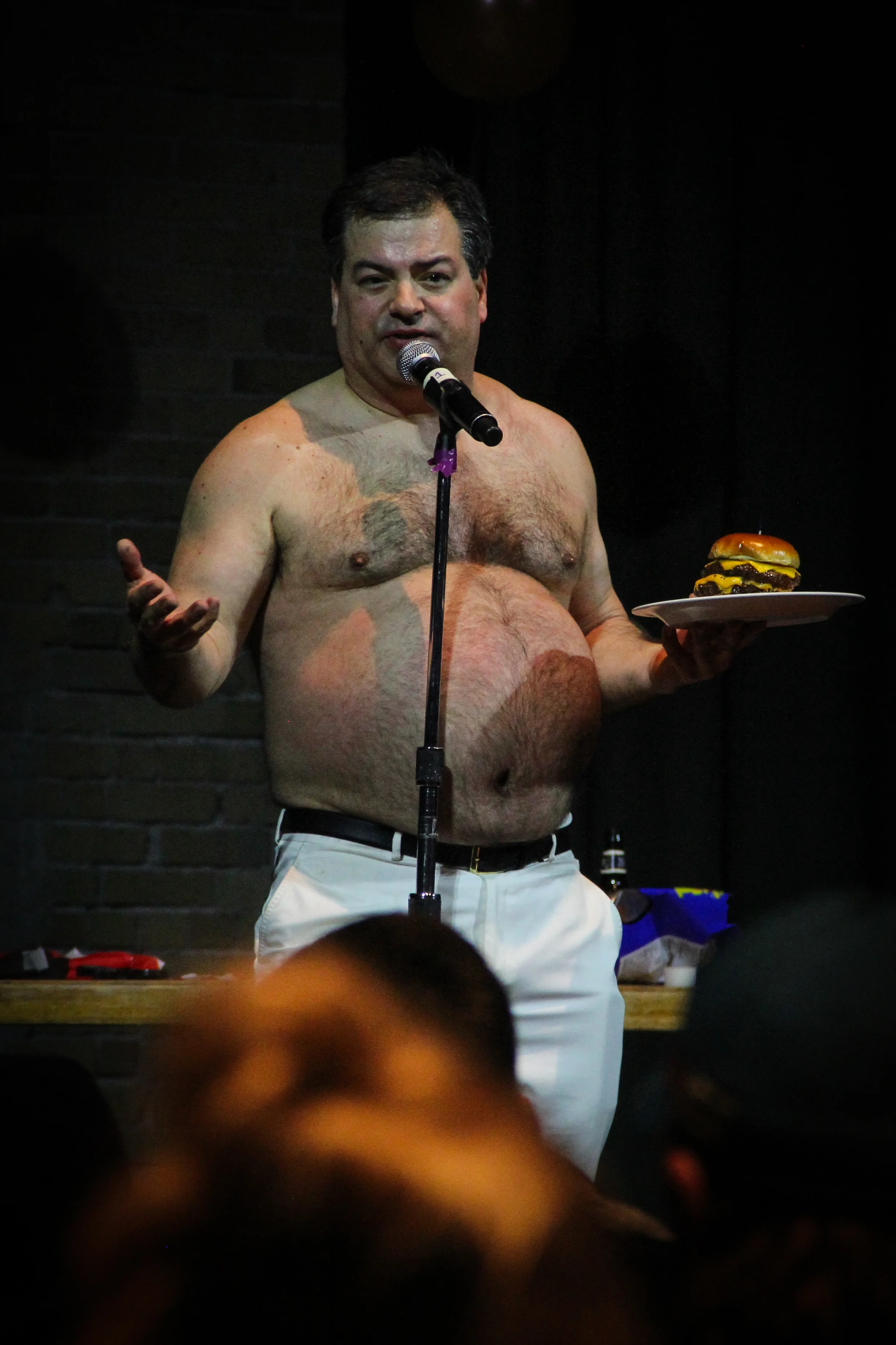 Patrick Roach posting shirtless with cheeseburger in hand. Photo by Kritsa Mathes