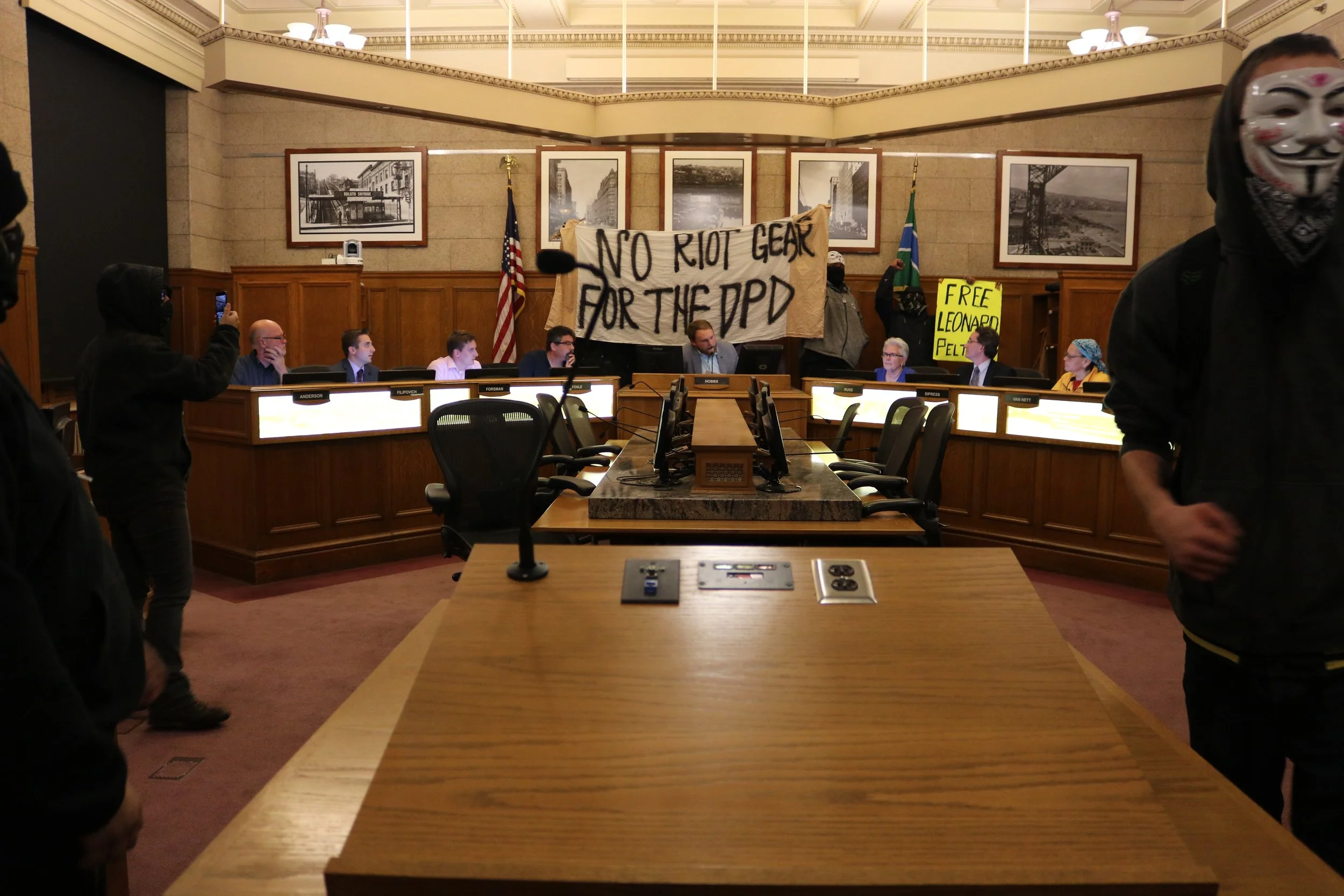 City Council Members from left to right; Gary Anderson, Zack Filipovich, Arik Forsman, Jay Fosle, Noah Hobbs, Barb Russ, Joel Sipress, Renee Van Nett and Em Westerlund. The City Council remained unwavered as protestors shouted all around them. Photo by Brianna Taggart
