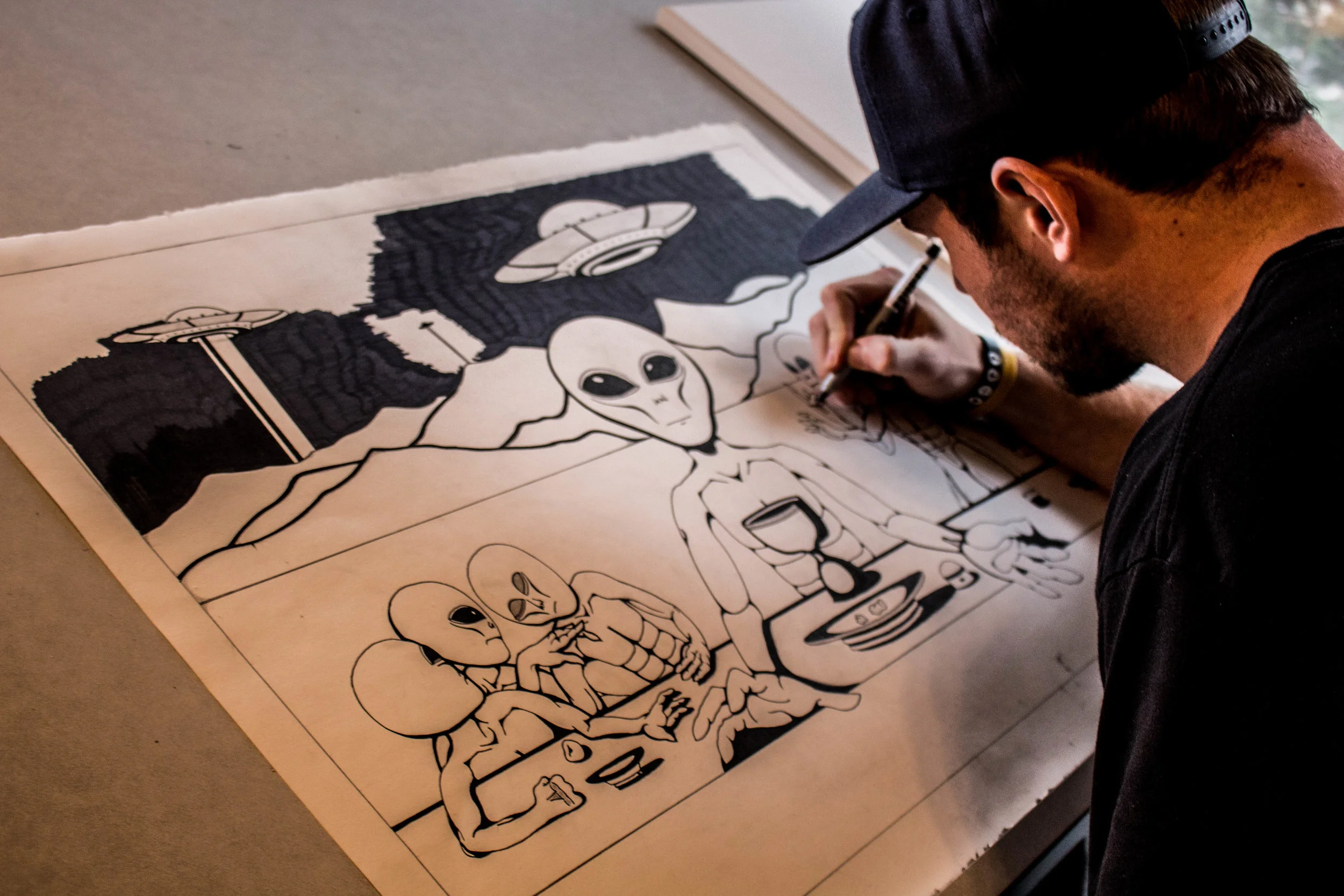 Dwyer sits in his room working on a drawing he calls “The First Supper”. Photo by Justin Flesher