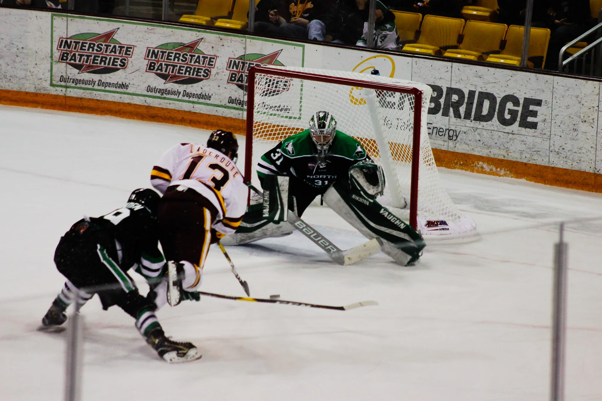 UMD freshman Tanner Laderoute (13) looks to score versus UND freshman goalie Adan Scheel at AMSOil. Photo by: Morgan Pint