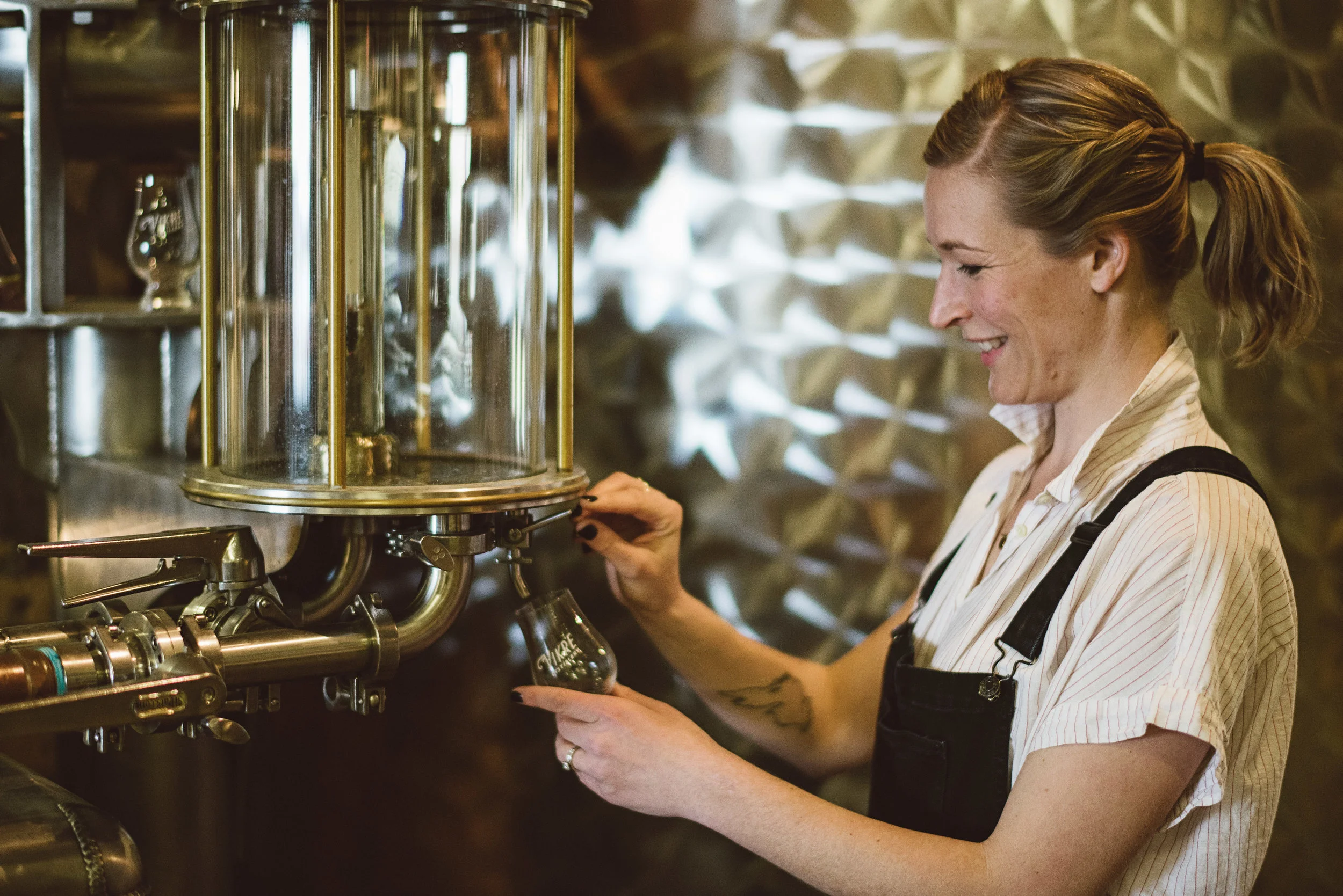 Co-owner, Emily Vikre, pouring a glass of spirits at The Vikre Distillery. Photo courtesy of Vikre Distillery