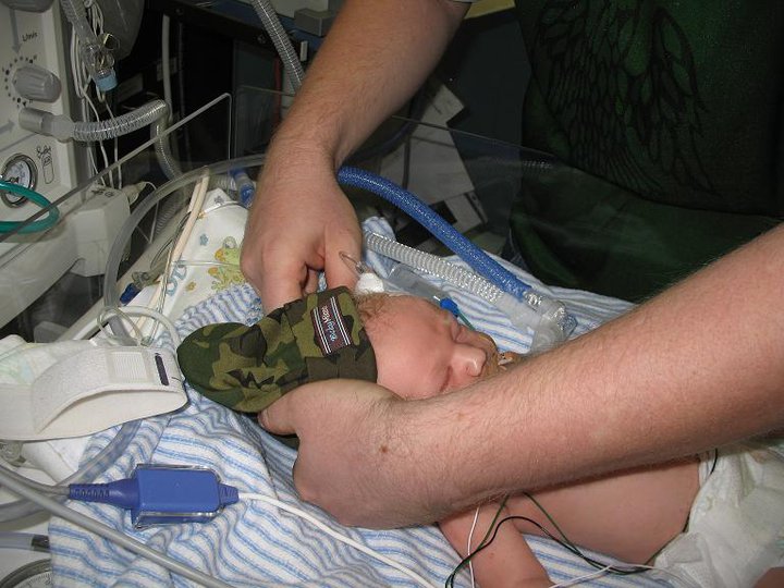 Daddy changing Evan into his little warriors camo hat from Grampa Chuck.