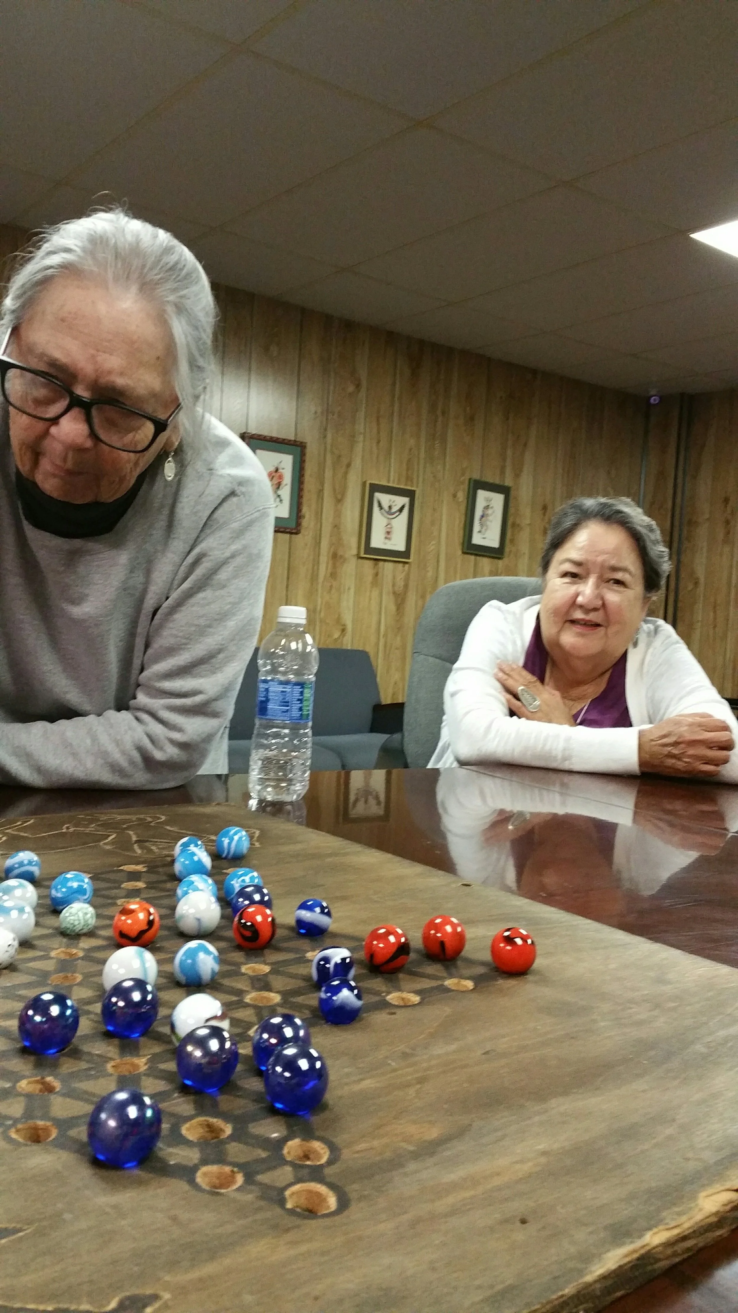Wahzhazhe leaders Rosemary Wood and Kathryn RedCorn playing Wahzhazhe marbles.