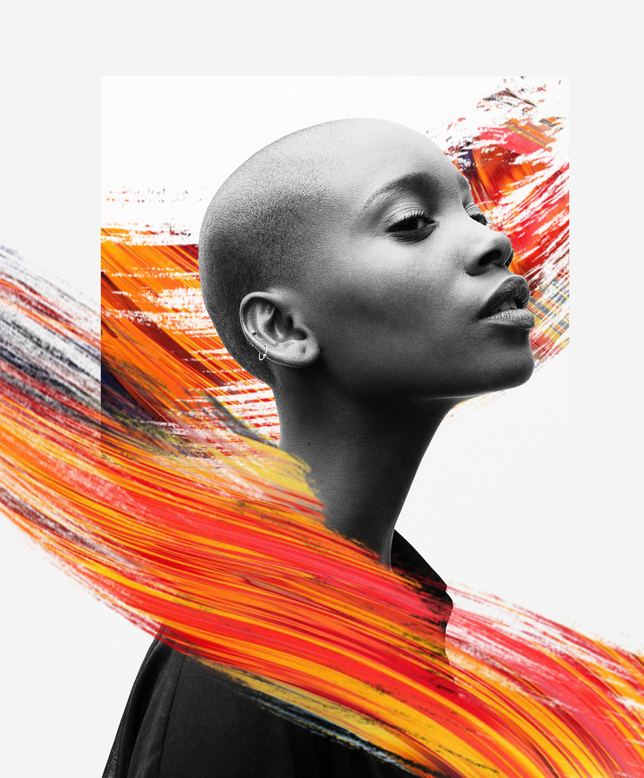 A black and white portrait of a woman with a shaved head and earrings, with abstract colorful orange, red, yellow, and white brush strokes in the background.