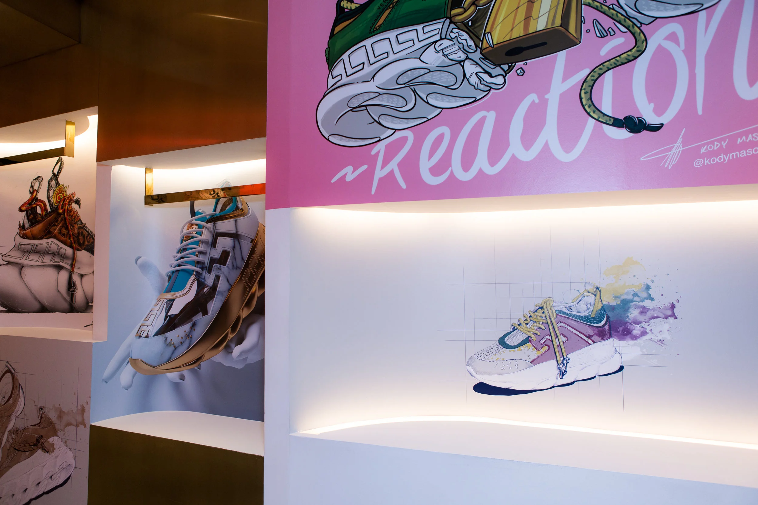 Showcase wall display Versace in New York featuring artistic illustrations of designer sneakers with colorful backgrounds and lighting.