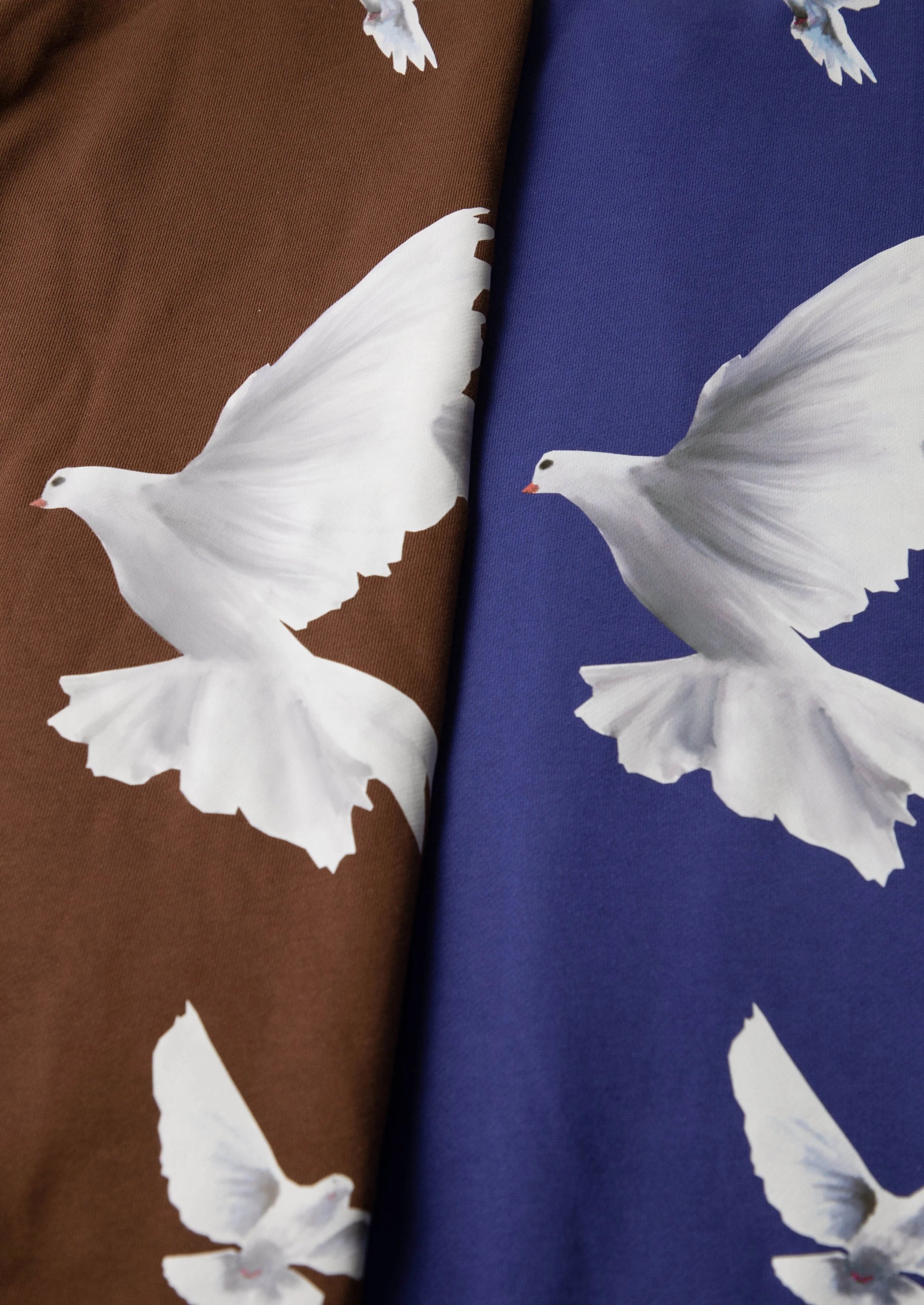 Close-up of fabric with a dove pattern, featuring white doves on brown and blue backgrounds. 3Paradis, high fashion, luxury print