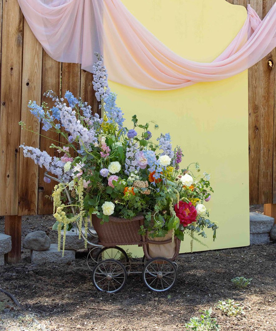 Unique floral arrangement in an antique baby carriage created for a baby shower