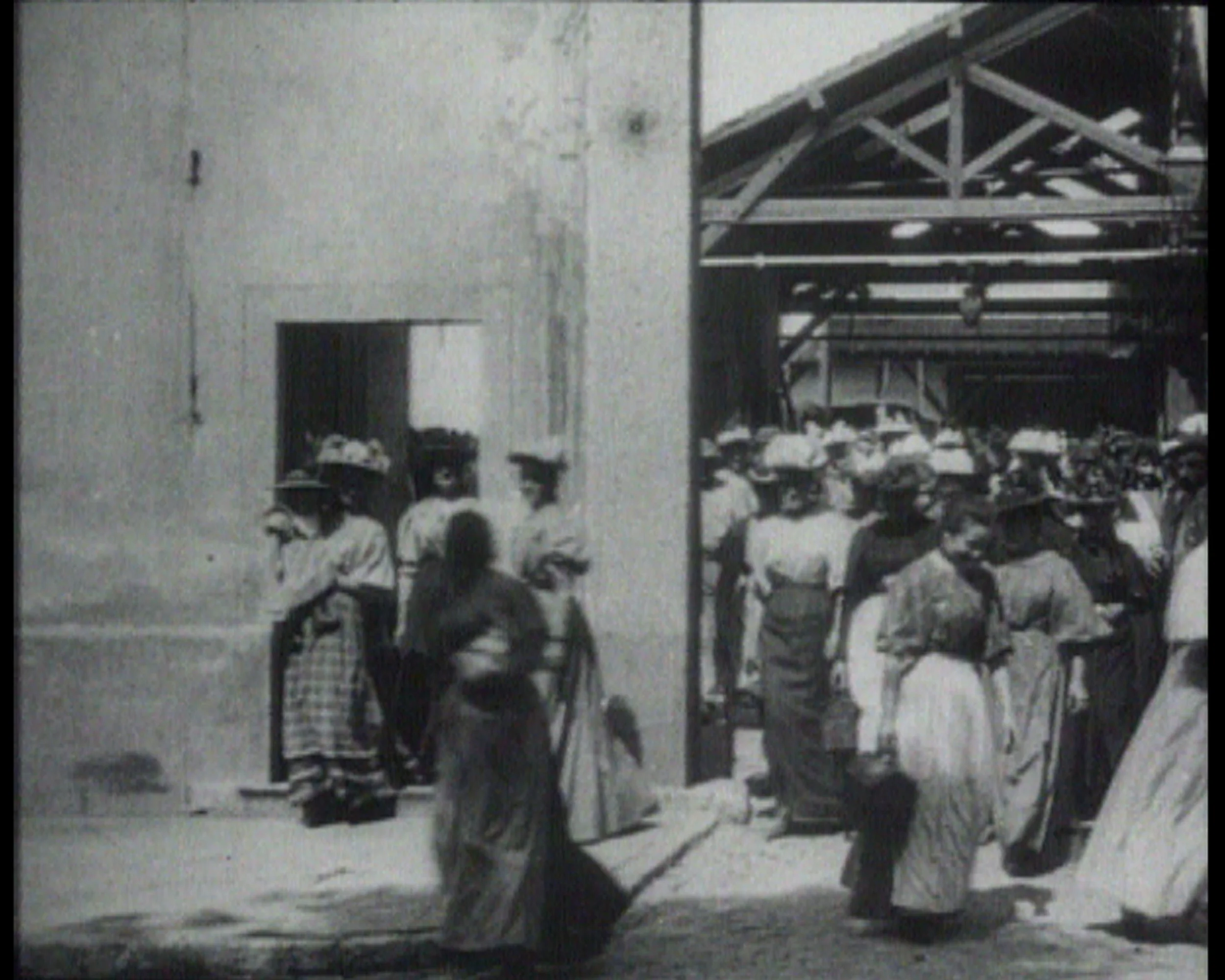 《工人离开工厂》,1995年,艺术家提供图片 Workers leaving the Factory, 1995, ©Harun Farocki 《工人离开工厂》是电影史上第一部公开放映的电影的名字。时长45秒,这部片子展现了里昂卢米埃兄弟的摄影产品工厂里的工人,摩肩接踵,匆匆从工厂大门的阴影中走出来,进入到下午的阳光里。只有在这里,工人们匆匆离去,他们才可视为一个社会群体。但是,他们要去往何处?去参加一个集会?还是遇见一个街垒?或是回家?这些问题被一代又一代的纪录片制作人所关注。工厂大门前的空间则一直被当做社会冲突的场景。而且,这部片子已成为电影史上叙事媒介的一个代表作品。在法罗基关于纪录片所作的同名文章中,他通过电影史探讨了这个场景。这一努力的结果就是成就了一篇从摄影媒介本身出发的出色电影分析,范围涉及广泛,从卓别林的《摩登时代》到弗里茨·朗的《大都会》,再到帕索里尼的《寄生虫》。如法罗基的电影所示,卢米埃兄弟的片子在其内部就蕴含着可预见的社会发展之萌芽:这种形式的工业劳动会终将消失殆尽。(克劳斯·格林豪恩,Hildesheimer Allgemeine Zeitung,1995年11月21日)。 Workers Leaving the Factory - such was the title of the first cinema film ever shown in public. For 45 seconds, this stillexistant sequence depicts workers at the photographic products factory in Lyon owned by the brothers Louis and Auguste Lumière hurrying, closely packed, out of the shadows of the factory gates and into the afternoon sun. Only here, in departing, are the workers visible as a social group. But where are they going? To a meeting? To the barricades? Or simply home? These questions have preoccupied generations of documentary filmmakers. For the space before the factory gates has always been the scene of social conflicts. And furthermore, this sequence has become an icon of the narrative medium in the history of the cinema. In his documentary essay of the same title, Harun Farocki explores this scene right through the history of film. The result of this effort is a fascinating cinematographic analysis in the medium of cinematography itself, ranging in scope from Chaplin's Modern Times to Fritz Lang's Metropolis to Pier Paolo Pasolini's Accattone!. Farocki's film shows that the Lumière brothers' sequence already carries within itself the germ of a foreseeable social development: the eventual disappearance of this form of industrial labor. (Klaus Gronenborn, Hildesheimer Allgemeine Zeitung, November 21, 1995)
