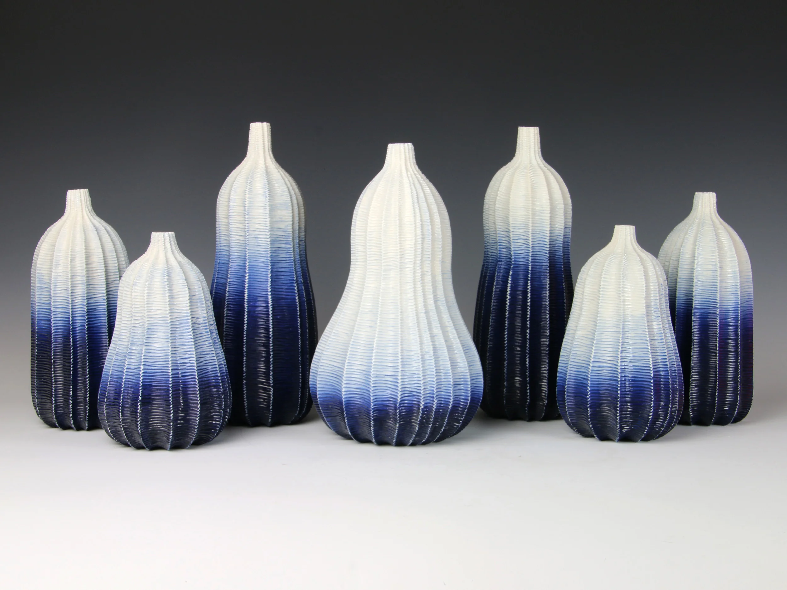 Indigo Ombre Garniture Of Seven Vases, 2014. Thrown and carved porcelain with cobalt oxide, height 26.5cm