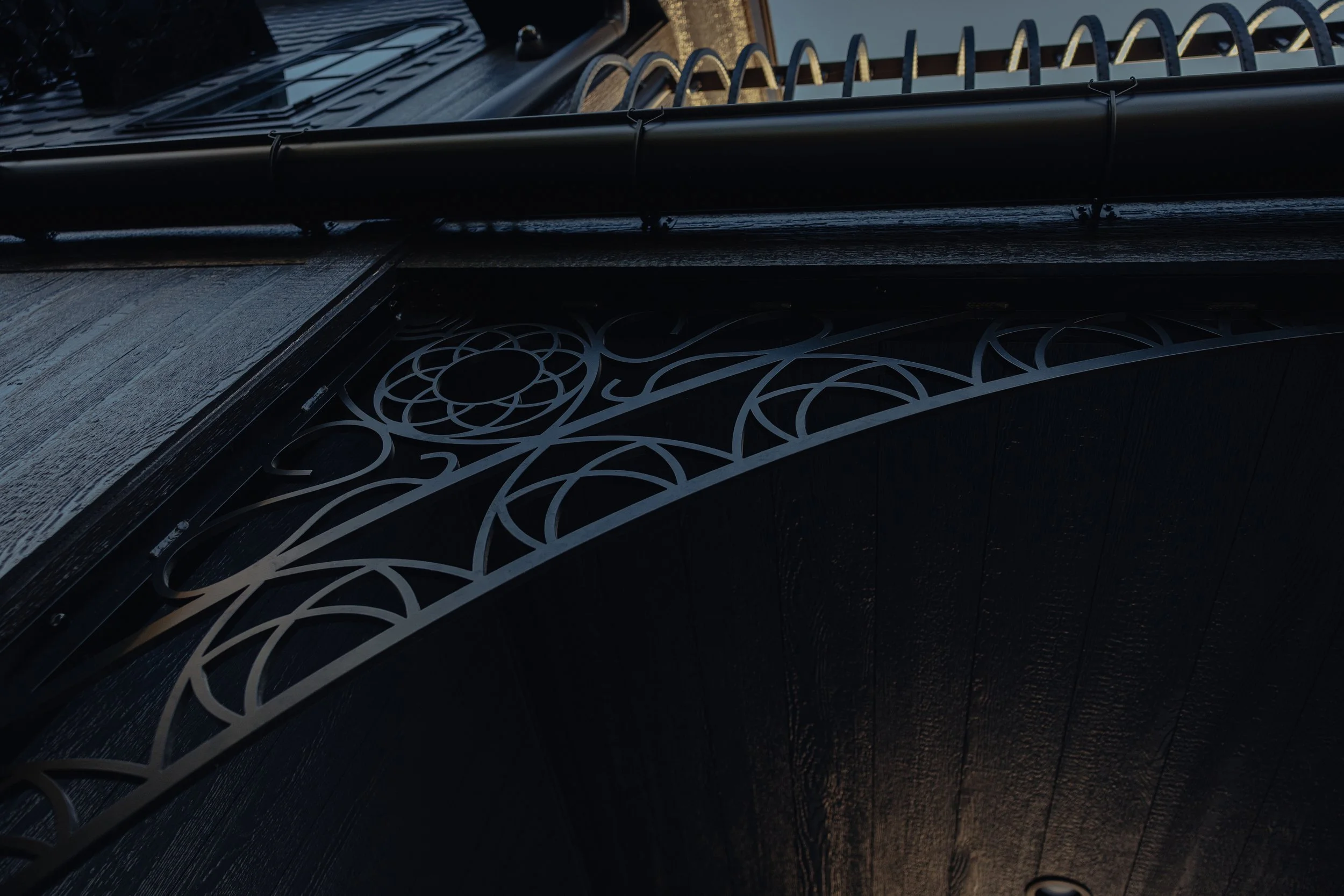  Custom steelwork including knee braces, balcony railing, and gutter detailing. 