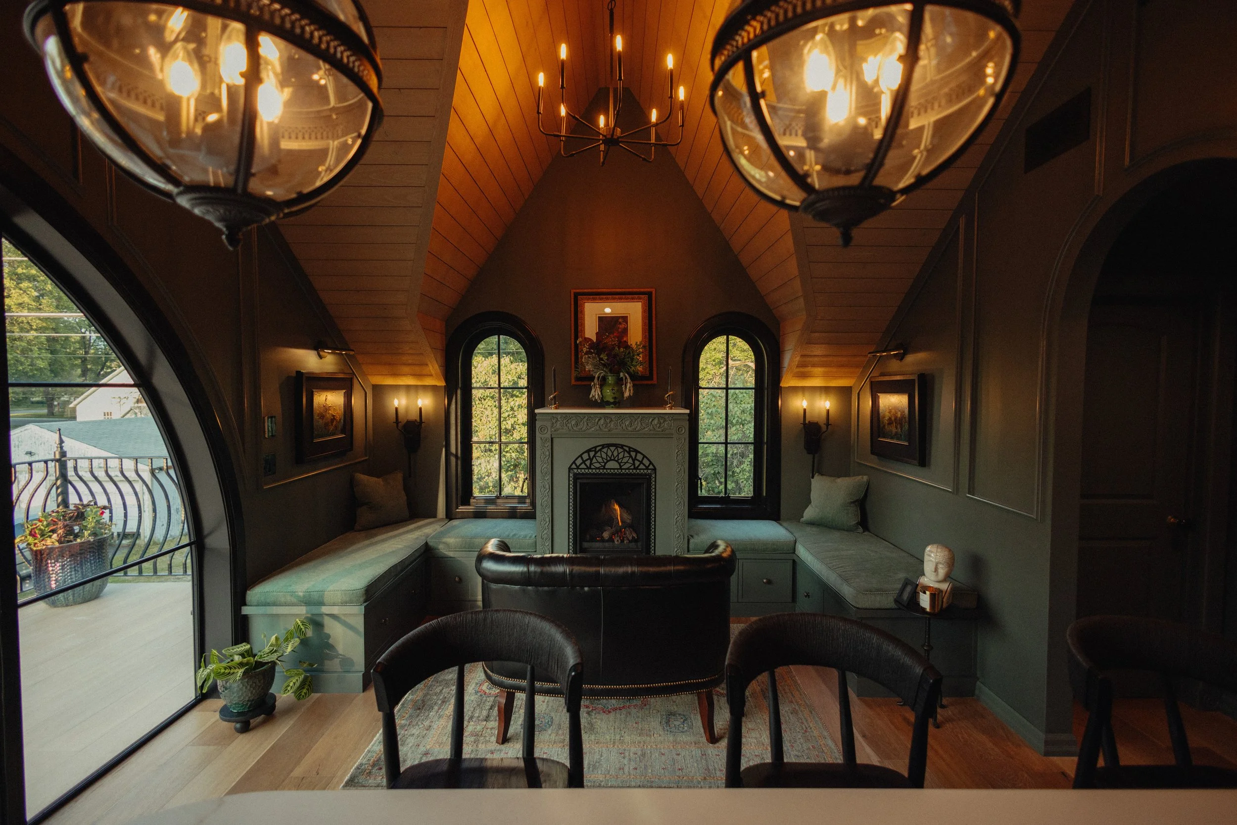  View from the kitchen toward the living room, built-in seating, fireplace, and arched balcony doors. 