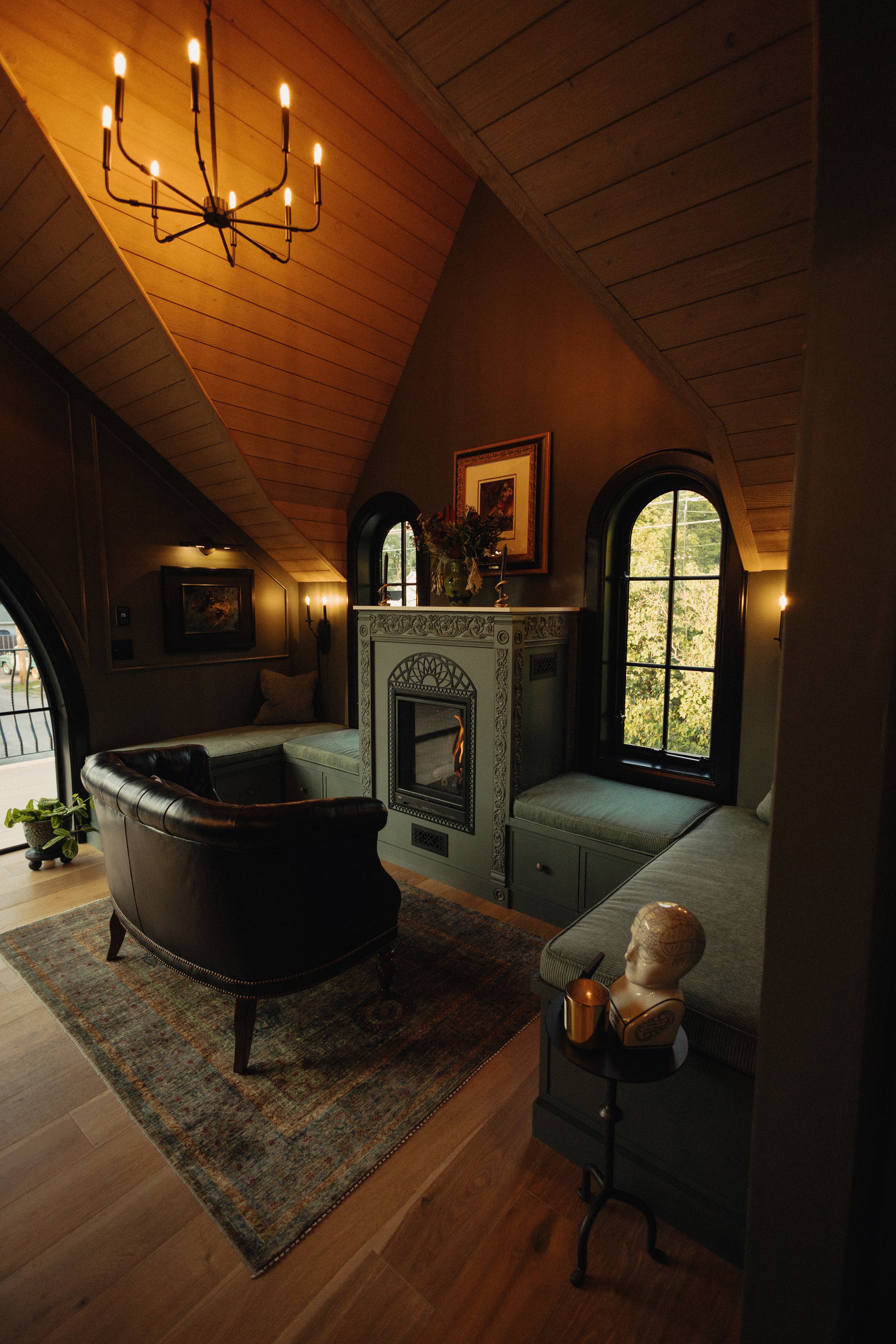  Living room with vaulted ceiling, arched windows, and central fireplace. 