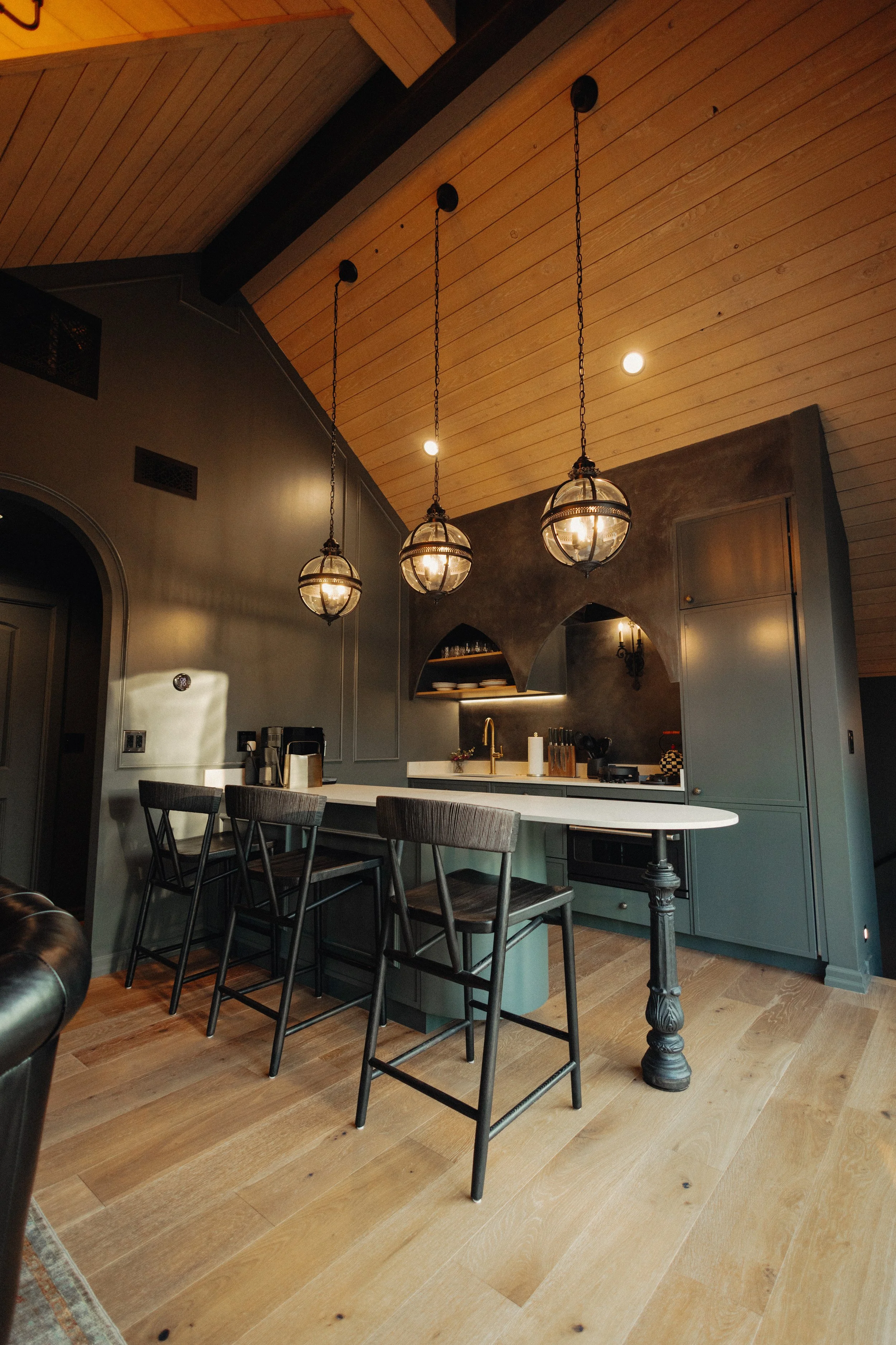  Compact kitchen with custom cabinetry and vaulted wood ceiling. 