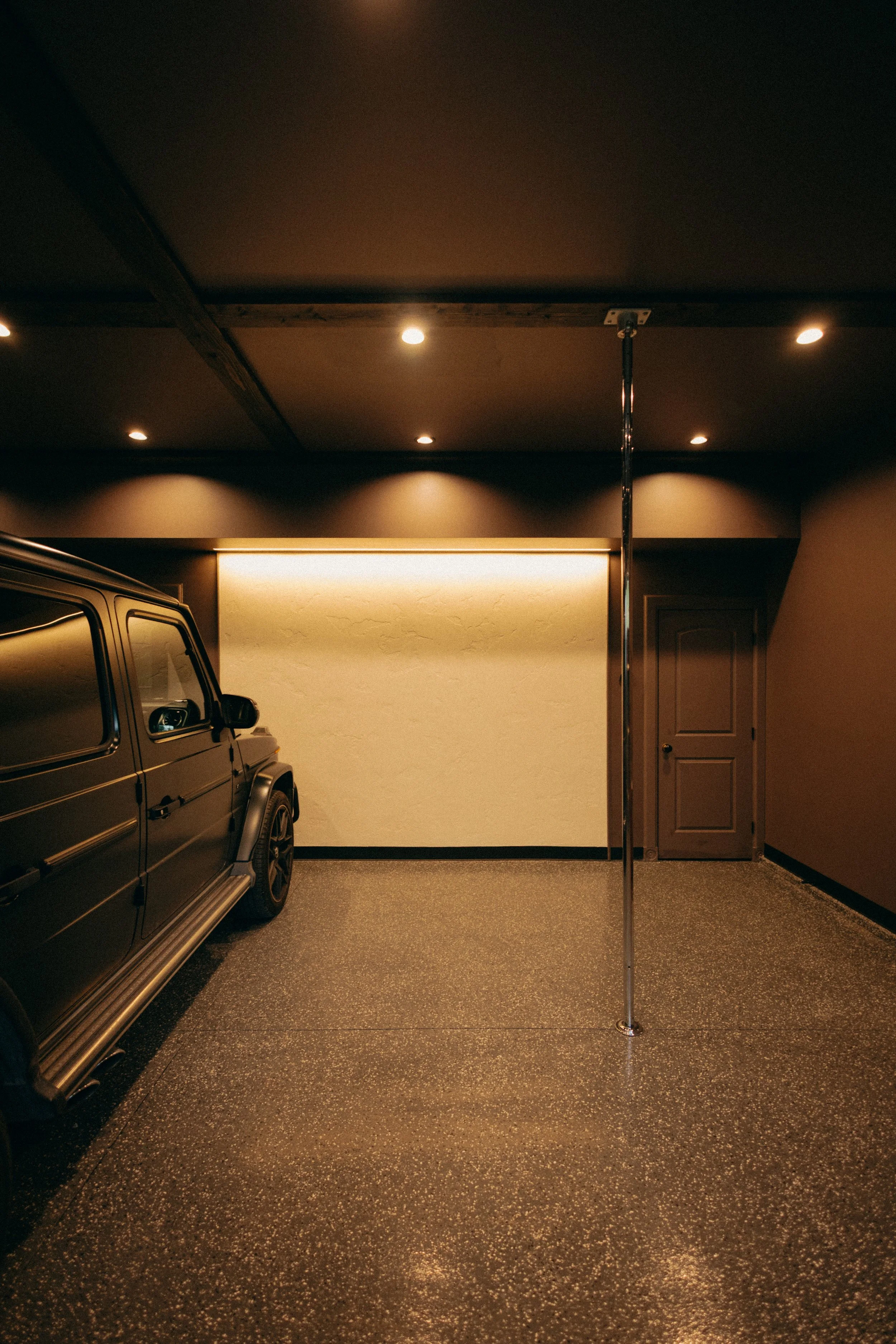  Garage interior with custom textured plaster feature wall and integrated lighting. 