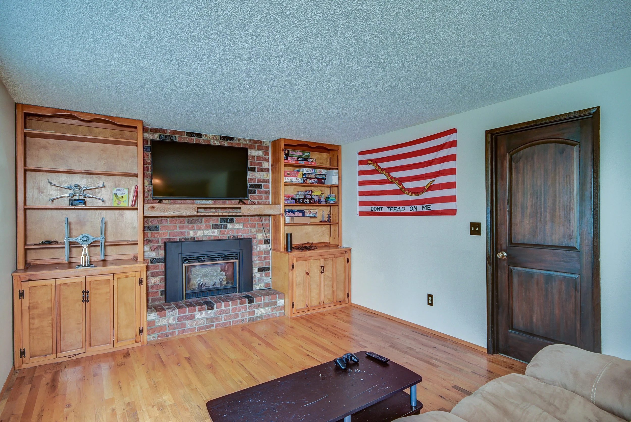 Family room with 2nd gas fireplace & brick surround--has wood floors, & built in storage! Can't you just imagine having game nights in here? Perfect!