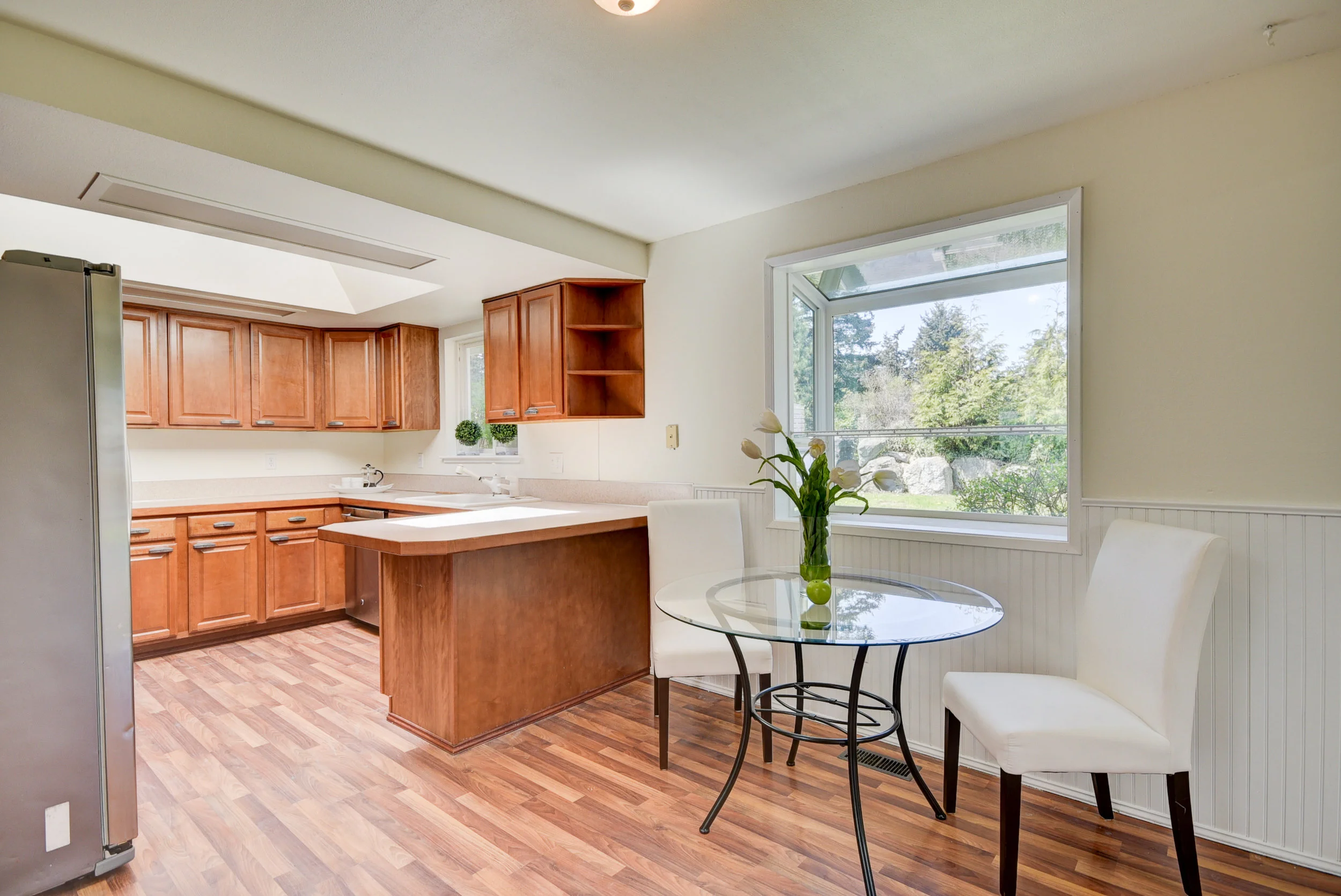 Maple cabinetry...stainless steel appliances, & another skylight & garden window let in tons of natural light...