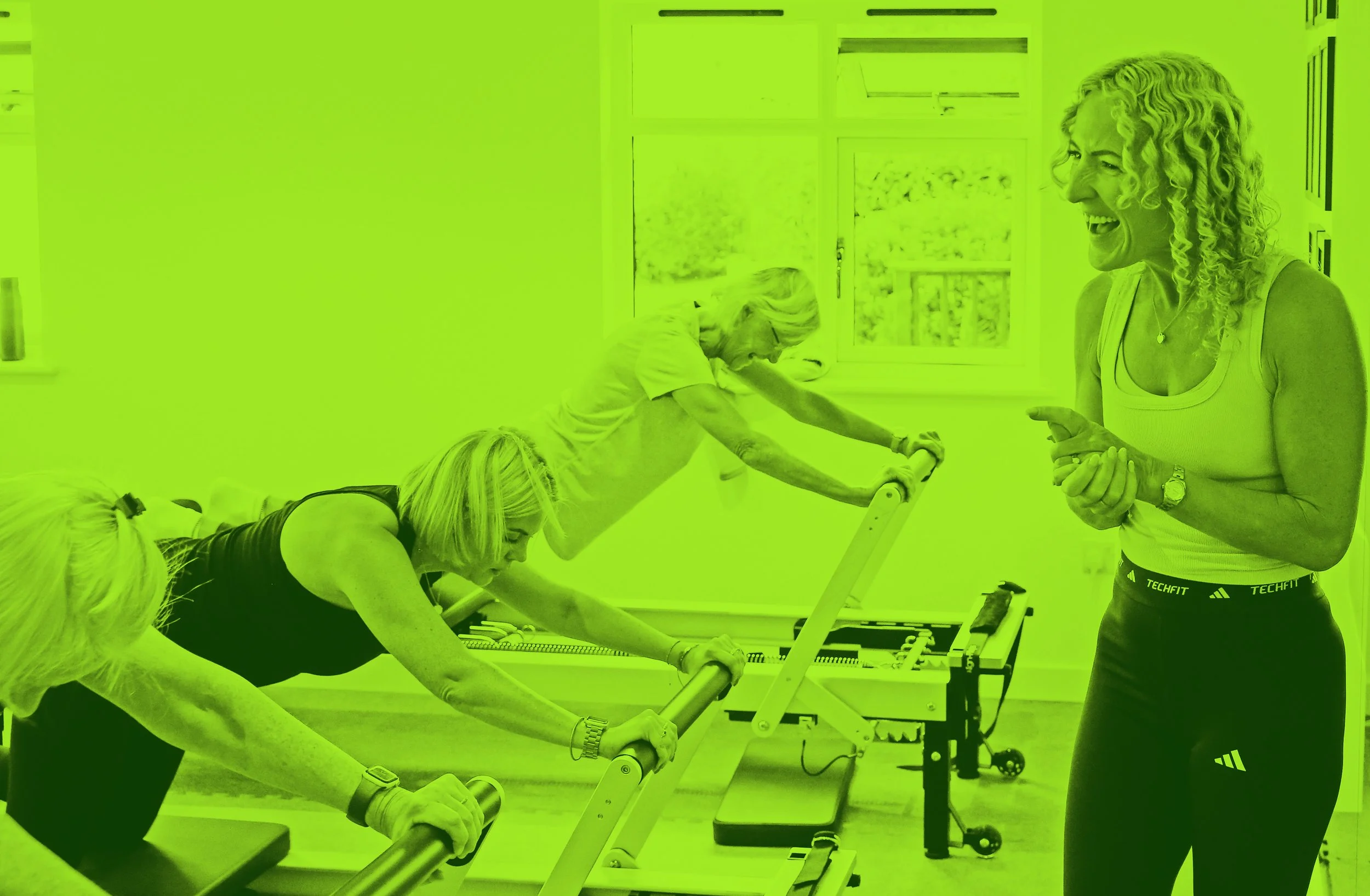 Suzy teaching a small reformer pilates class at Equilibrium, clients working on Align-Pilates reformers in a bright mirrored studio