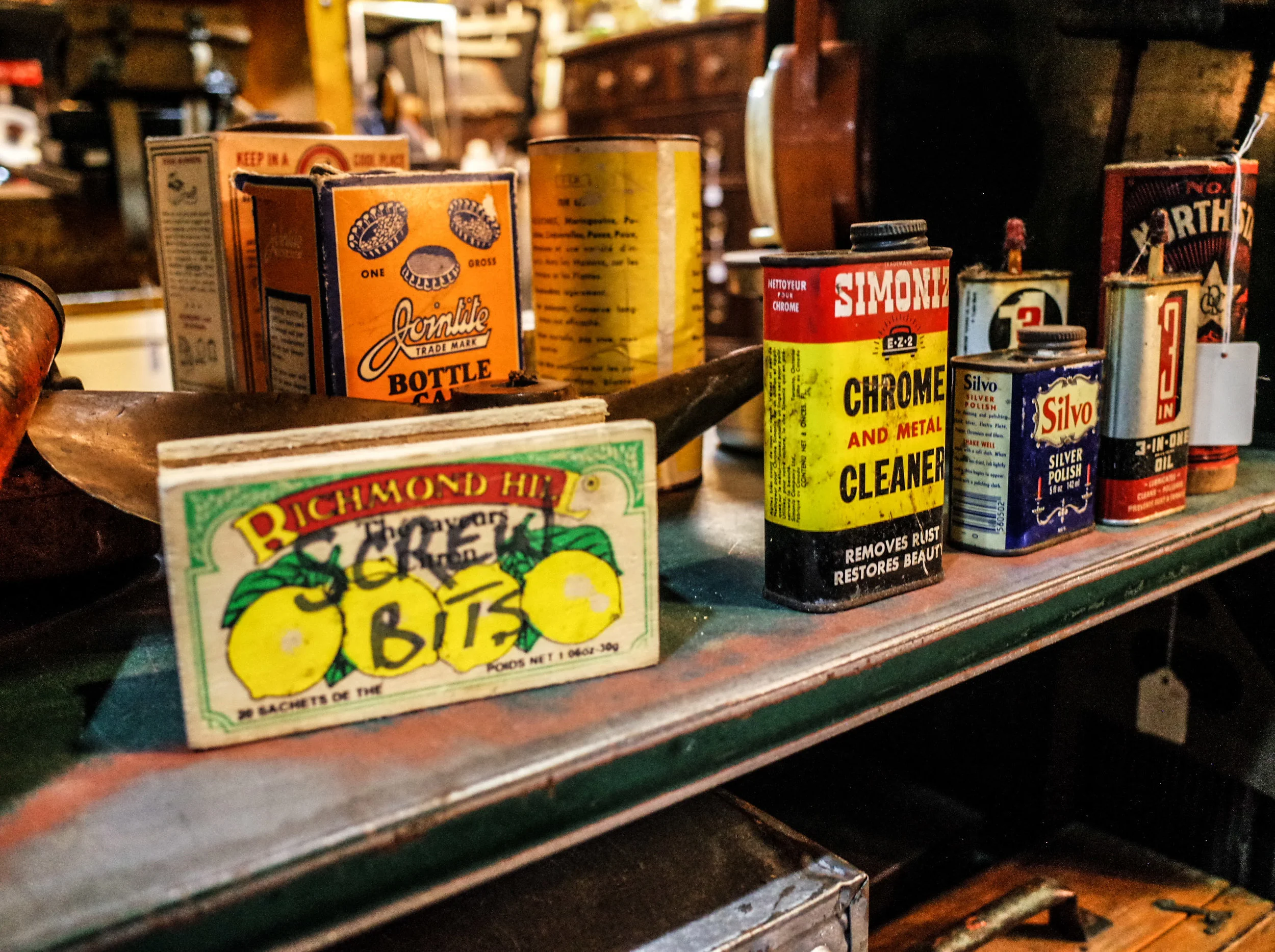 A collection of vintage tin cans, retro packaging, and antique advertising items on a shelf at Space Lab Vancouver, linking to the unique objects of interest page.