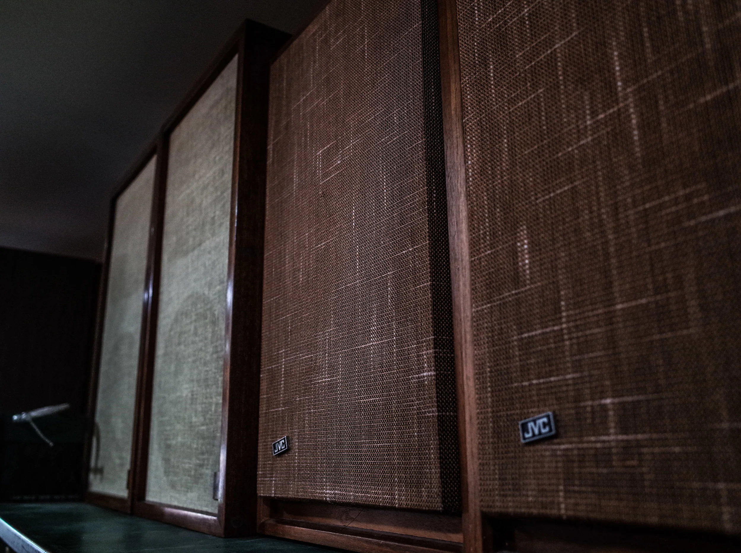 A row of vintage JVC speakers with wooden cabinets on display at Space Lab Vancouver, linking to the retro audio equipment collection page.