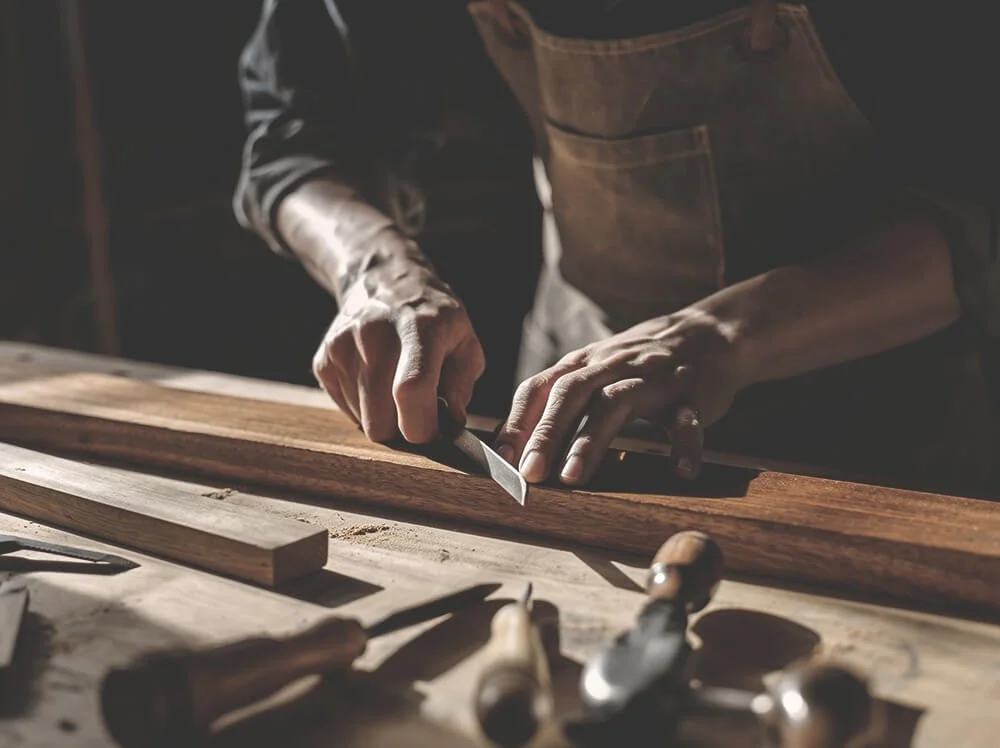 Skilled artisan hands crafting custom furniture using traditional woodworking tools at Space Lab Vancouver.
