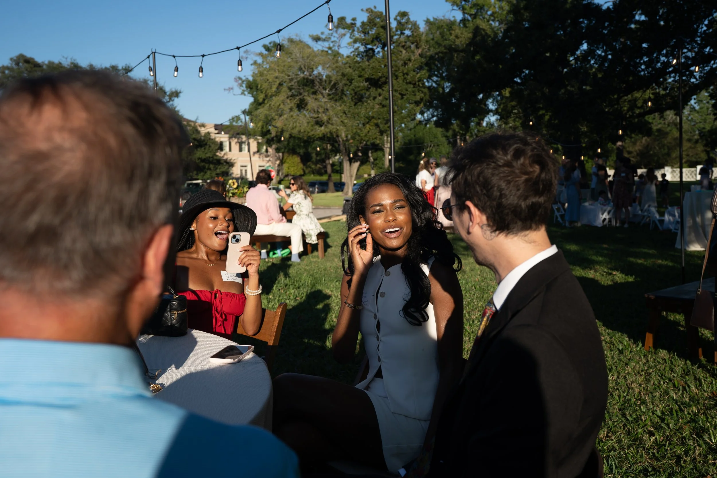 Houston wedding magician performing strolling close-up magic for guests during an outdoor cocktail hour at a wedding reception.