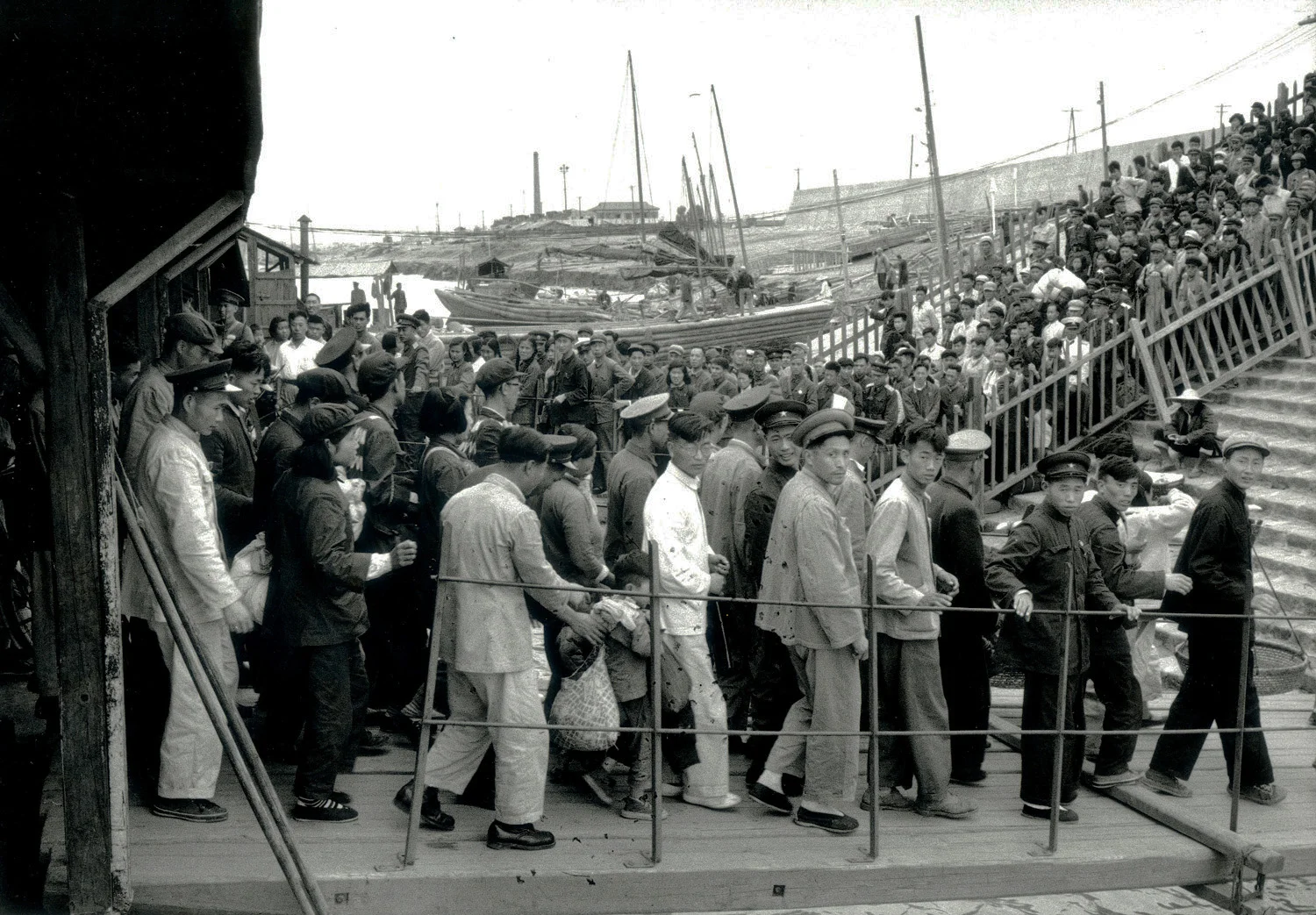 A large crowd embarking and disembarking from a ferry terminal in Hunan Province, China, May 1956. (RDH C05-13a)