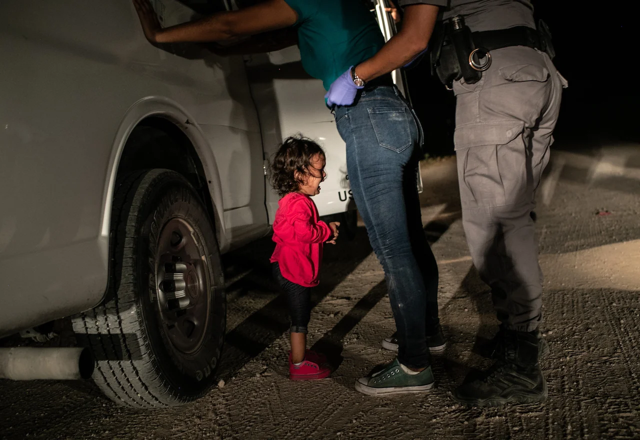 John Moore: Yanela, from Honduras, cries as her mother Sandra Sanchez is searched by a US Border Patrol agent, in McAllen, Texas, USA, on 12 June © John Moore