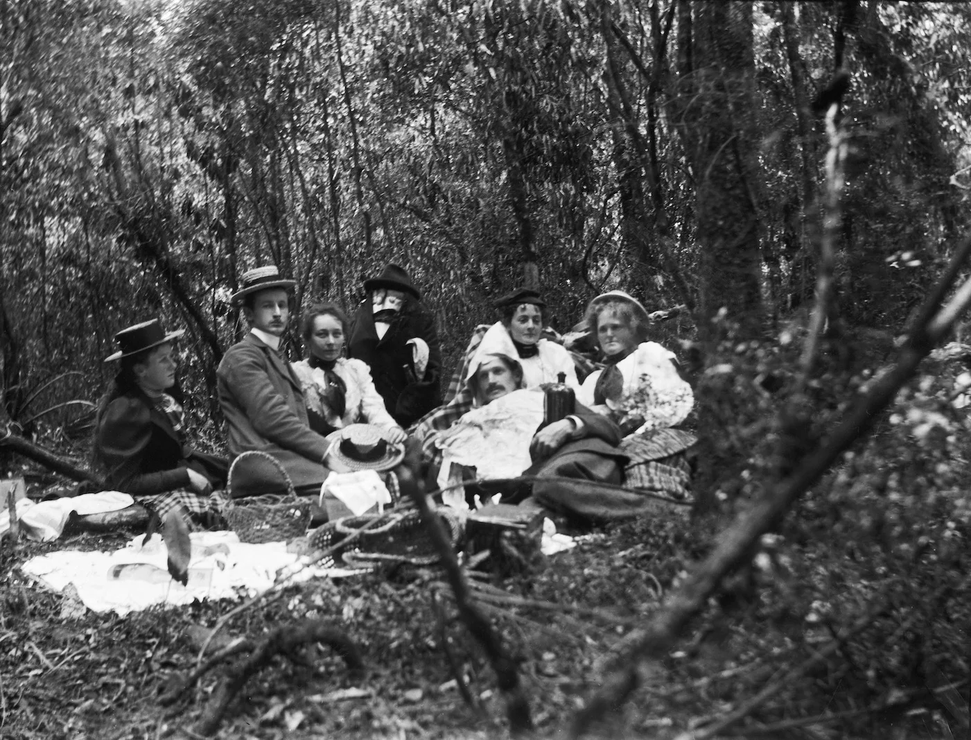 Some next level shenanigans at an Edwardian picnic in the New Zealand bush, likely North Island circa 1907-1911. Lemuel Lyes Collection.