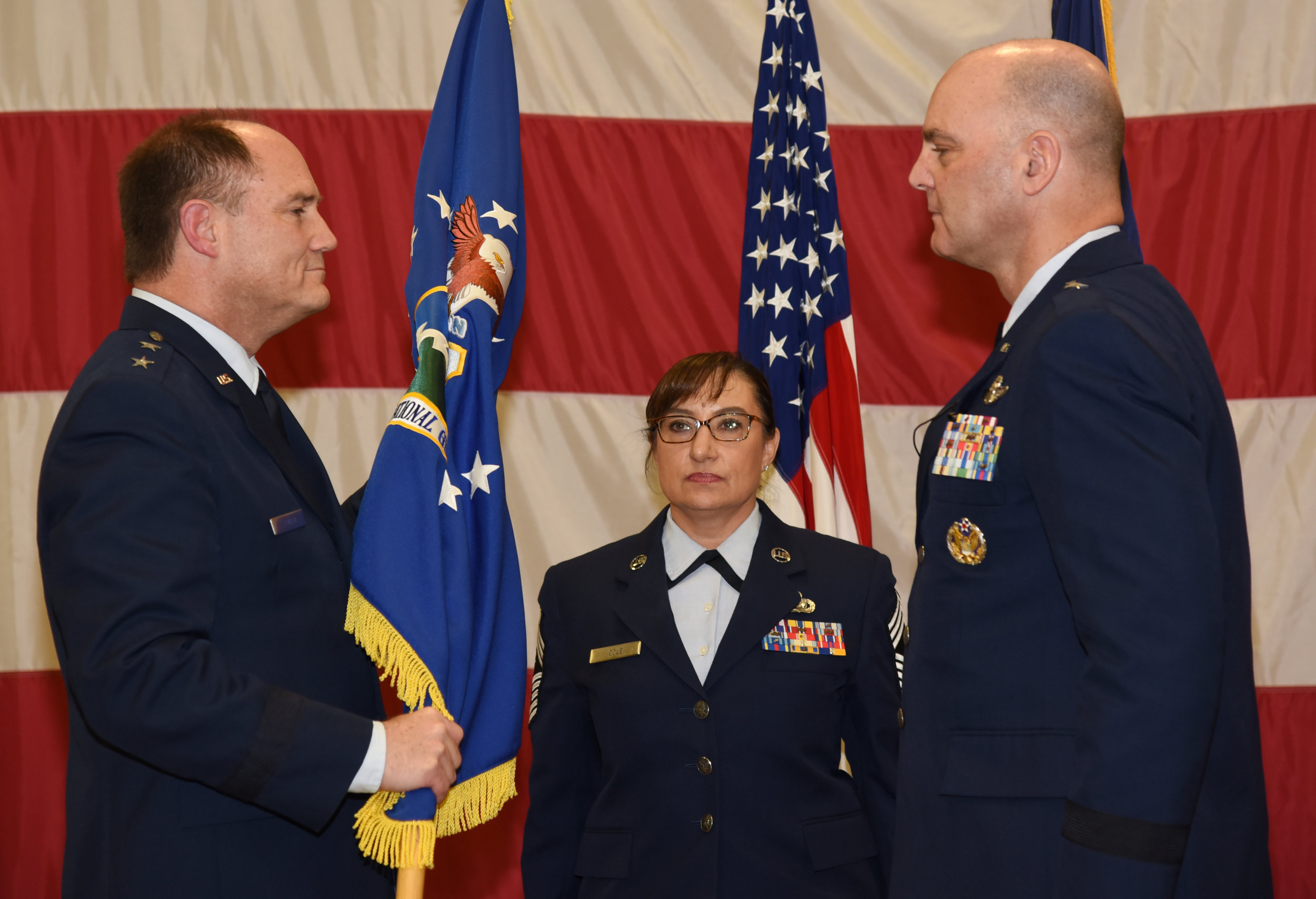  Brig. Gen. James R. Kriesel (right), incoming commander, Oregon Air National Guard, assumes command from Maj. Gen. Michael E. Stencel (left), Adjutant General, Oregon, as Chief Master Sgt. Ulana Cole, State Command Chief, looks on during a change of