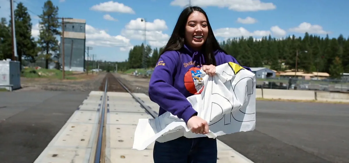 Chiloquin junior Lani Jackson tears apart a sign stating “Trouble” in a video created by leadership students last spring.