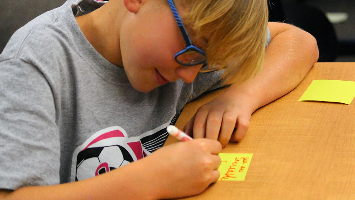 Luke Balzotti writes kind notes to classmates during the first Kindness Club meeting at Henley Elementary School.