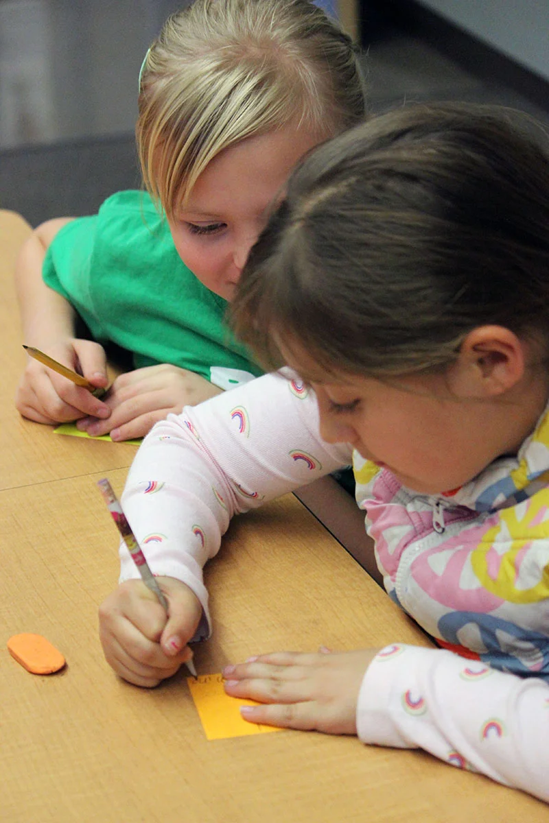 Shayla Carter and Jubilee Matkins write and pass out kind notes to classmates during the first Kindness Club meeting at Henley Elementary School.