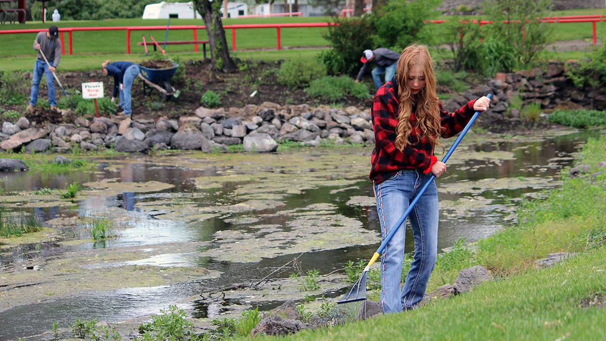 Haylee Hansen, a senior at Bonanza Junior-Senior High School, cleans up around the natural springs at Big Springs Park in Bonanza.