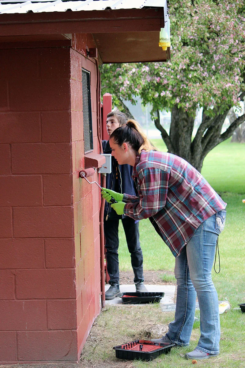 Bonanza high school students repaint the restroom walls at Big Springs Park on Thursday as part of an annual Give Back Day event.
