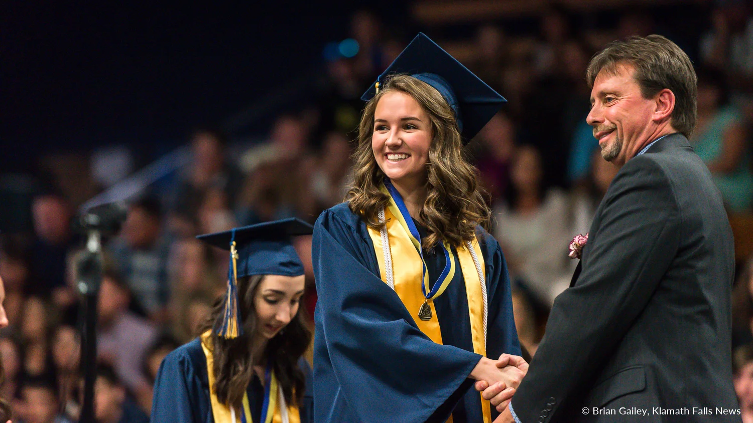 File photo - Principal Jack Lee of Henley High School shakes the hand of a student at the HHS 2018 graduation ceremony. (Image, Brian Gailey / Klamath Falls News).