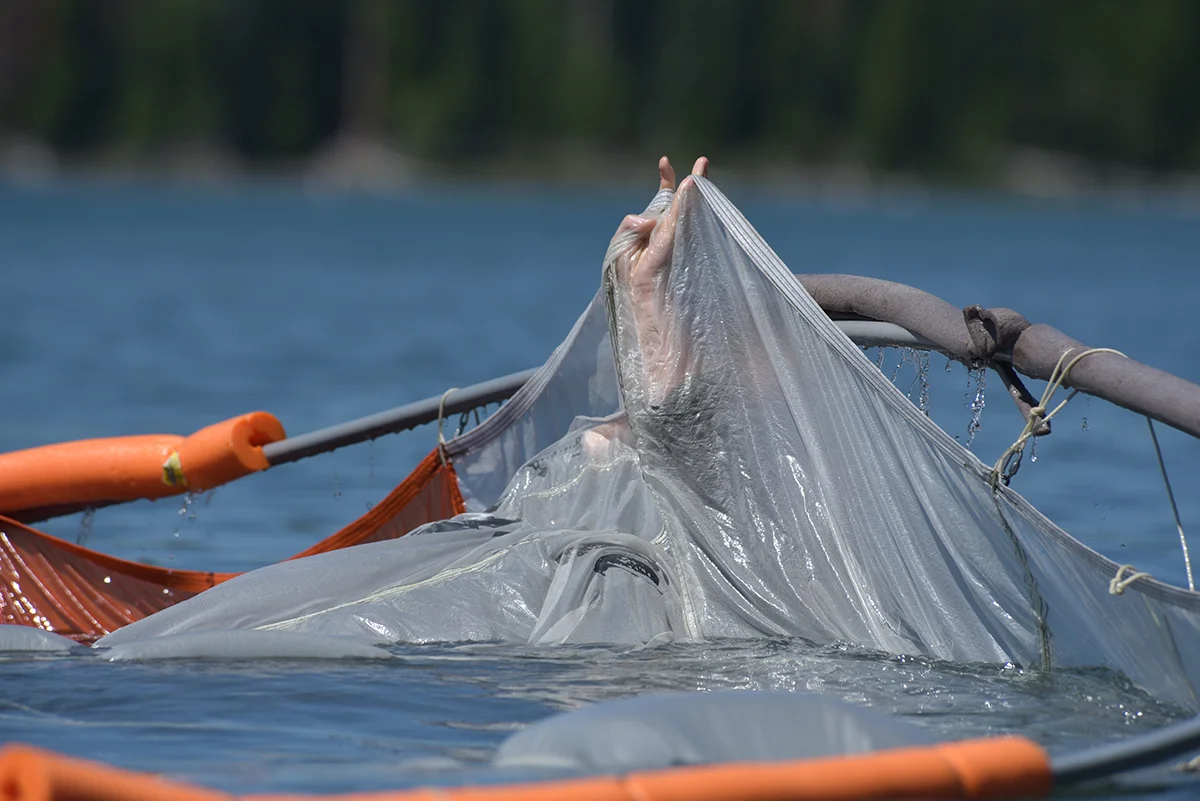 U.S. Air Force Lt. Col. Kedric Osborne, an F-15C Instructor Pilot at the 173rd Fighter Wing, navigates underneath a floating parachute canopy during water survival training at Cultus Lake, Oregon, July 25, 2019. The training occurs every three years and is necessary for flying and training the F-15C over water; something these pilots do when using the ranges over the Oregon and California Coast. (U.S. Air National Guard photo by Master Sgt. Jefferson Thompson)