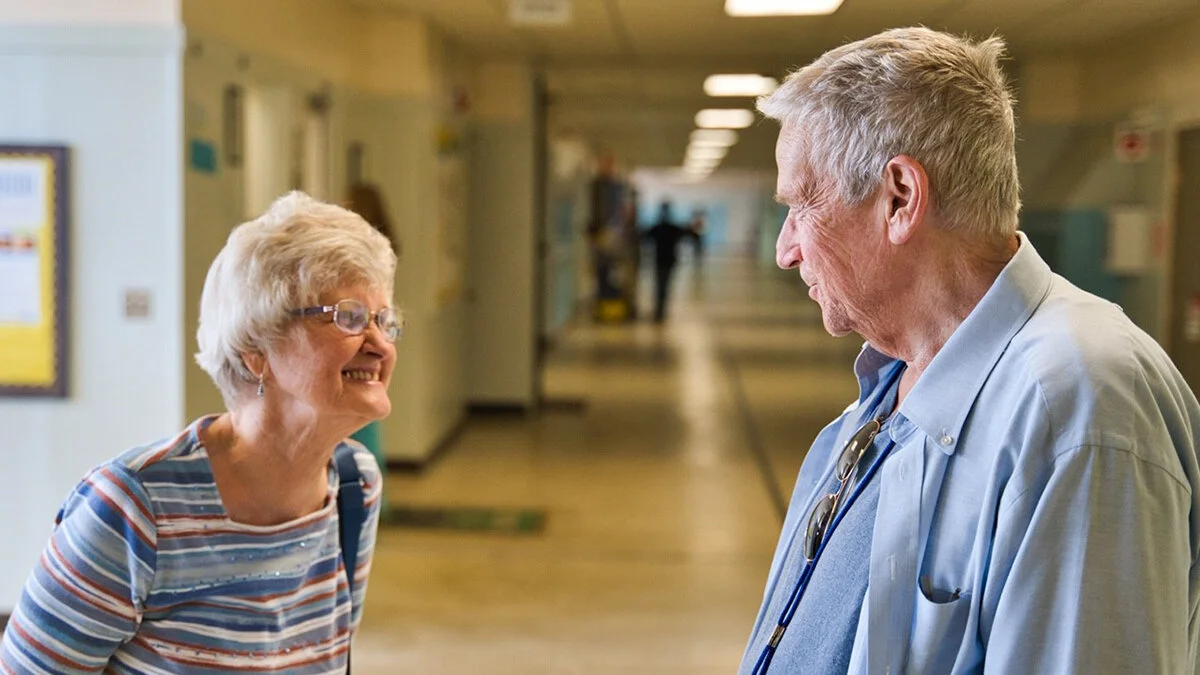 Larry Ferguson, a 1958 Henley High School, graduate and renowned director and screenwriter, greets his former drama and English teacher, Jayne Stuntebeck, during a visit to his alma mater last month. Stuntebeck is one of the teachers Ferguson credits with his chosen profession and success. Photo by Morgan Abramson.
