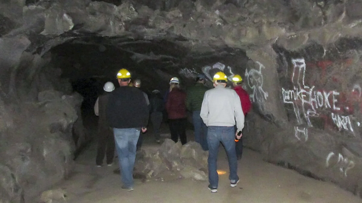 Hard-hatted and headlighted visitors have the opportunity to visit Barnum Cave each Fall on a free guided tour led by experts from the Service, Klamath National Forest and the local cave protection society. Because of increased vandalism and threats to cave and bat health, the U.S. Forest Service installed a heavy, locked iron gate to prevent human access when bats are present in the cave. Credit: Jennifer Jones/USFWS