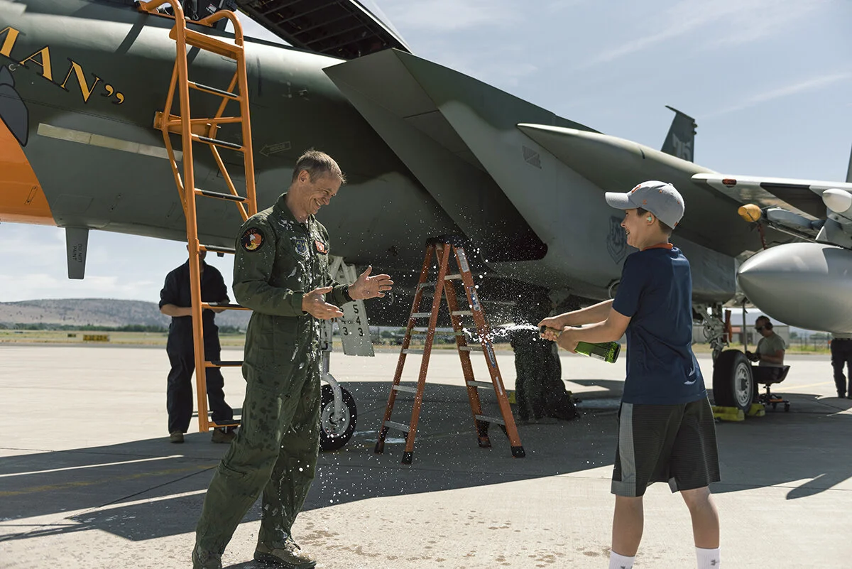 U.S. Air Force Colonel Geoffrey Jensen, 173rd Operations Group commander, endures a celebratory shower of champagne from his son at Kingsley Field in Klamath Falls, Oregon, June 24, 2020. On this flight, Jensen accomplished 3,000 flight hours in the Eagle, joining a select group of “Eagle Drivers”. (U.S. Air National Guard photo by Senior Airman Adam Smith)