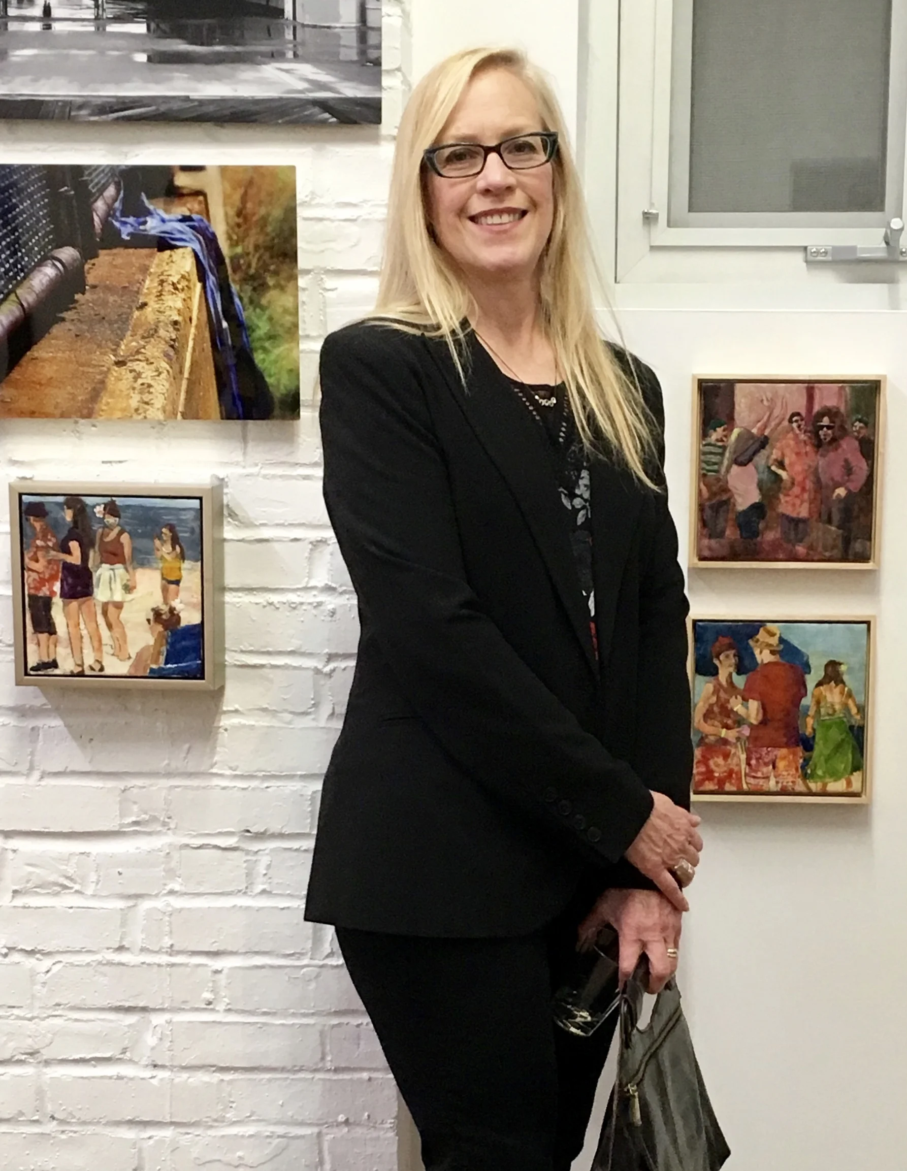 The artist pictured with 3 encaustics among other work at Open Orange.