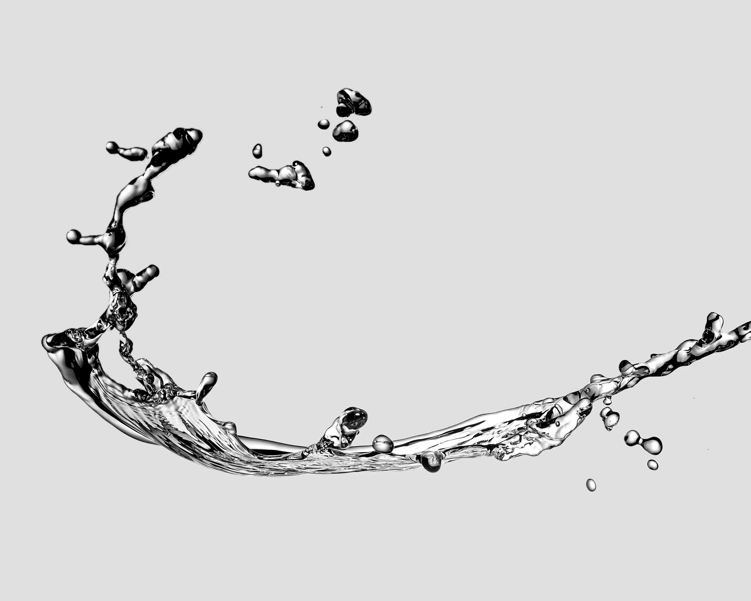 Black and white image of water splashing against a gray background.