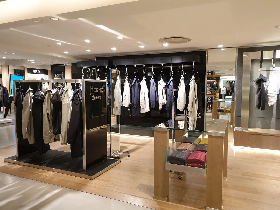 Stylishly lit fixtures and caribiner hung product at Herno.