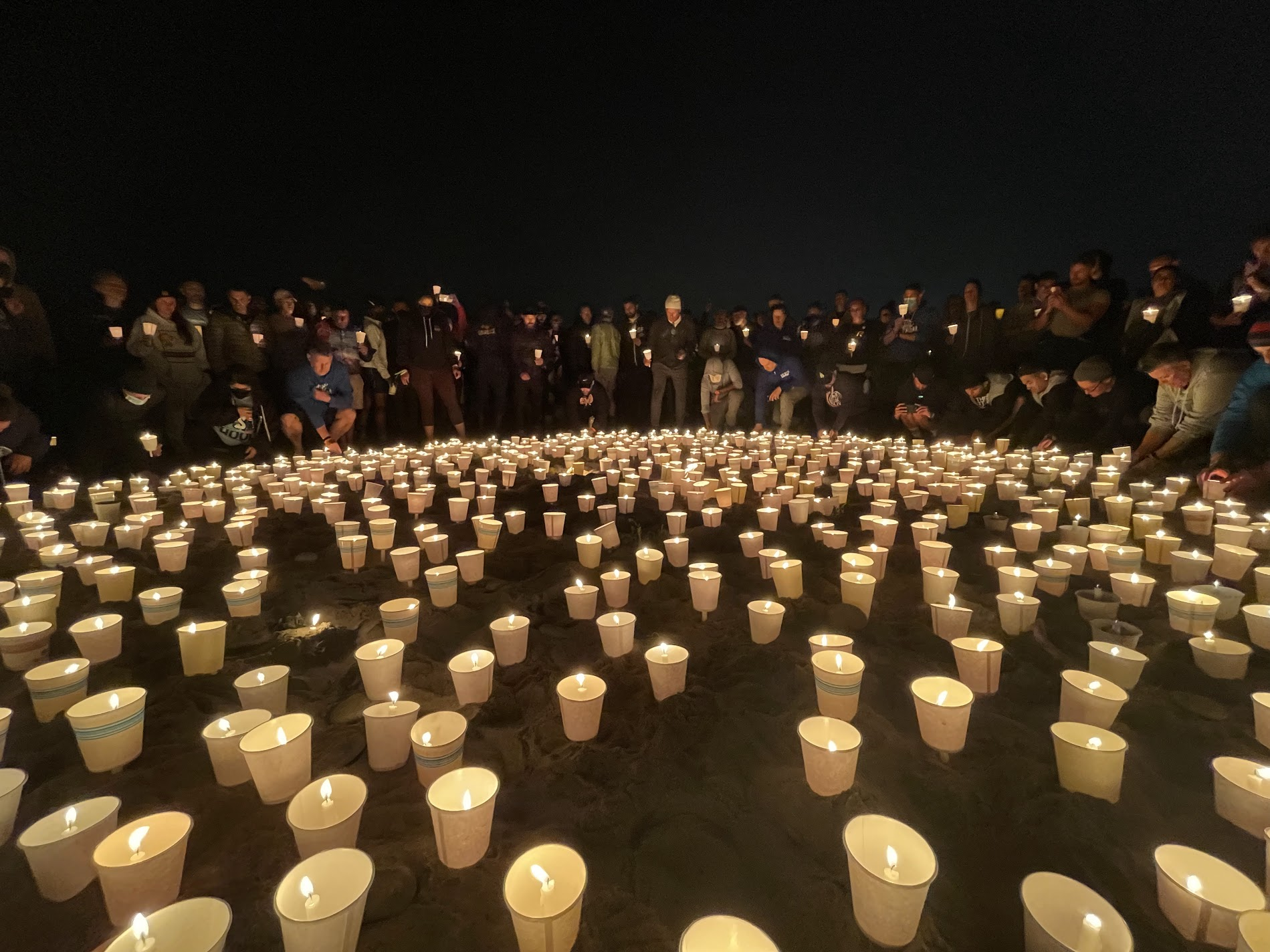 hundred of lanterns laying in the sand on the beach