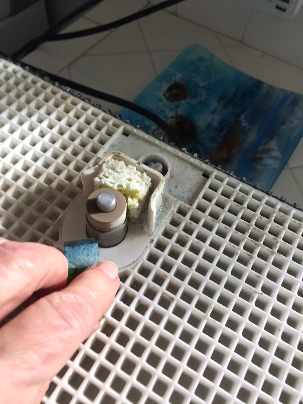 I put on my rubber coated garden glove and my respirator (glass dust is not good for the lungs) and begin grinding the glass pieces to consistent shapes with my glass grinder. I only grind off sharp and irregular edges. The glass will round off in the kiln when I fire it again.