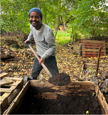 Nathan from De Meent shovelling compost during his visit to Stadsboerderij Osdorp