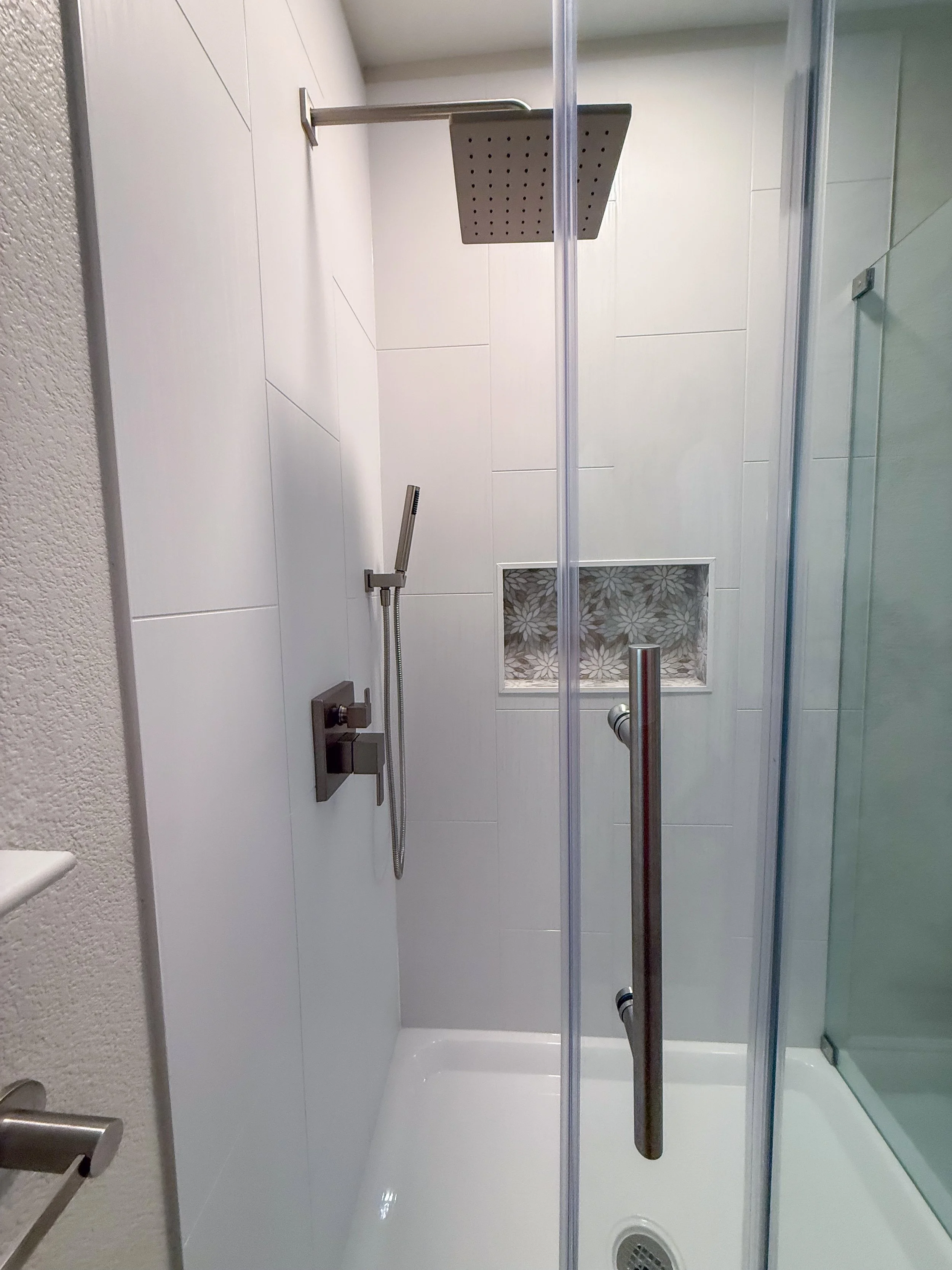 bathroom remodel, contemporary, renovation, vanity, single sink vanity, pendant lighting, hanging lighting, contemporary mirror, bathroom wall removal, brushed nickel, hardware mix, black hardware, bathroom decor, flower tile, wallpaper, bold