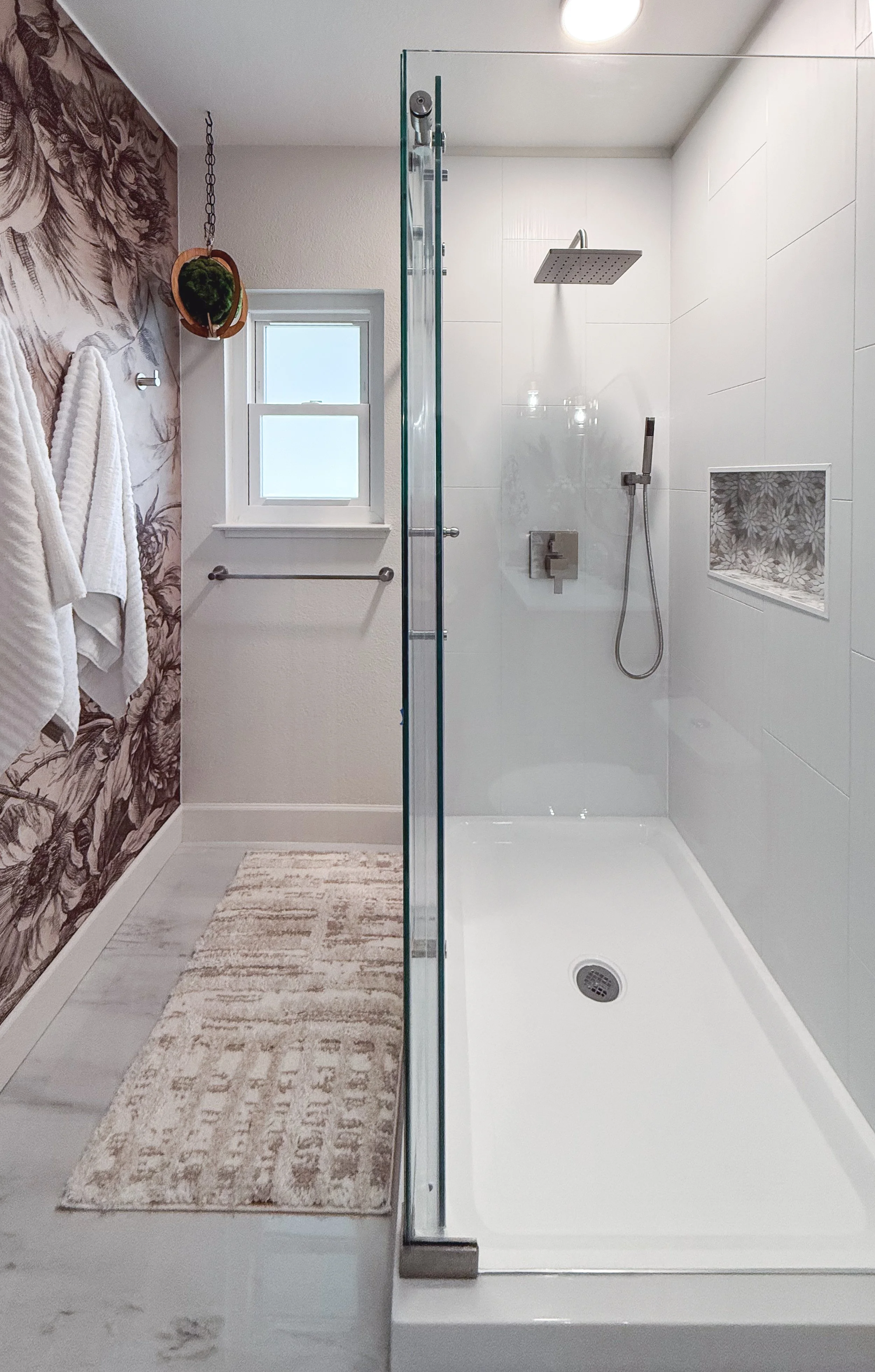 bathroom remodel, contemporary, renovation, vanity, single sink vanity, pendant lighting, hanging lighting, contemporary mirror, bathroom wall removal, brushed nickel, hardware mix, black hardware, bathroom decor, flower tile, wallpaper, bold