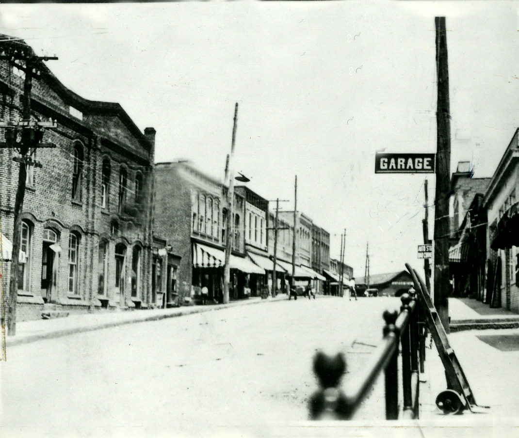 Looking up Main Street this establishment is on the left with the striped awning. Notice the telephone poles still on Main St